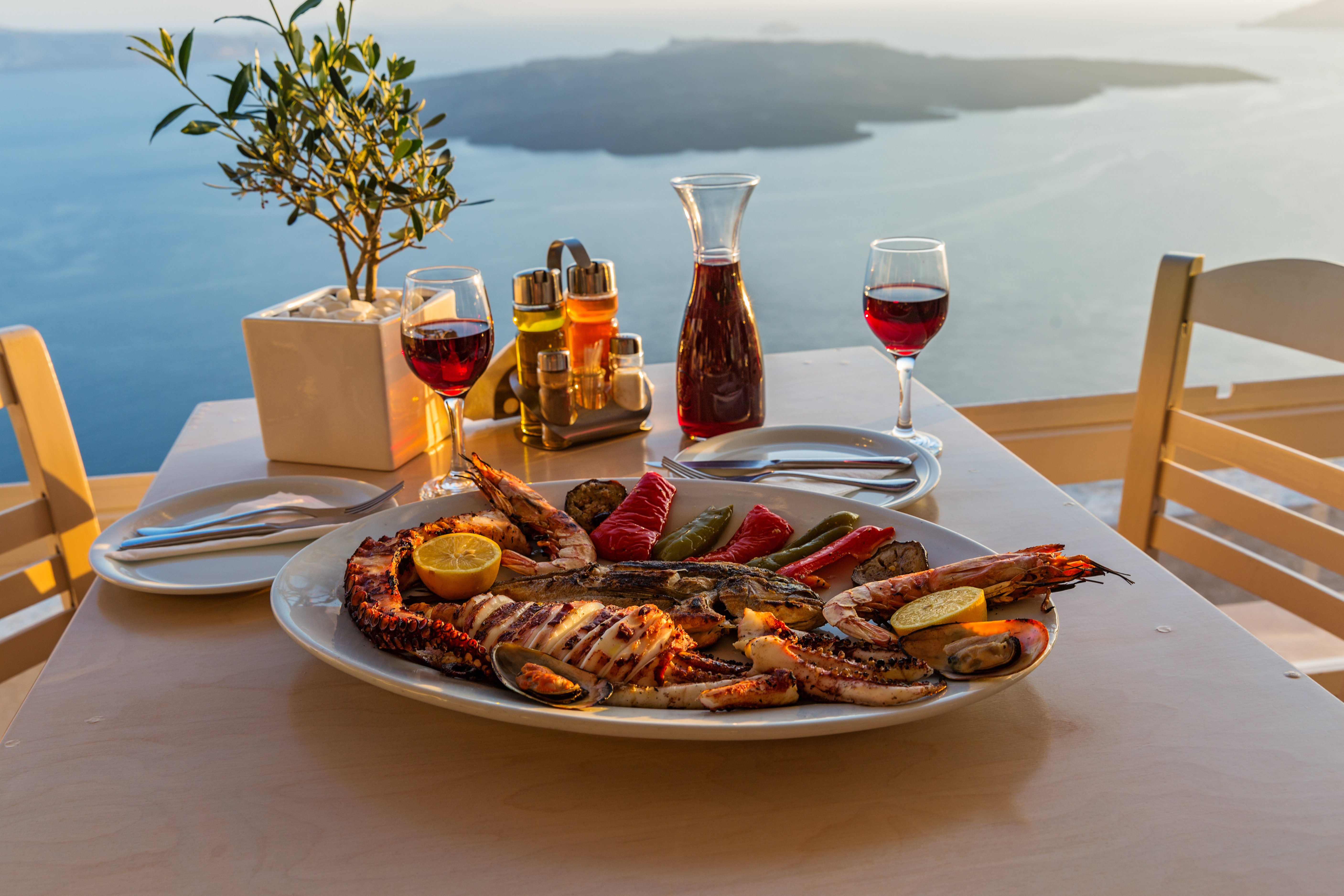 Evening dinner with seafood and red wine on the beach sea