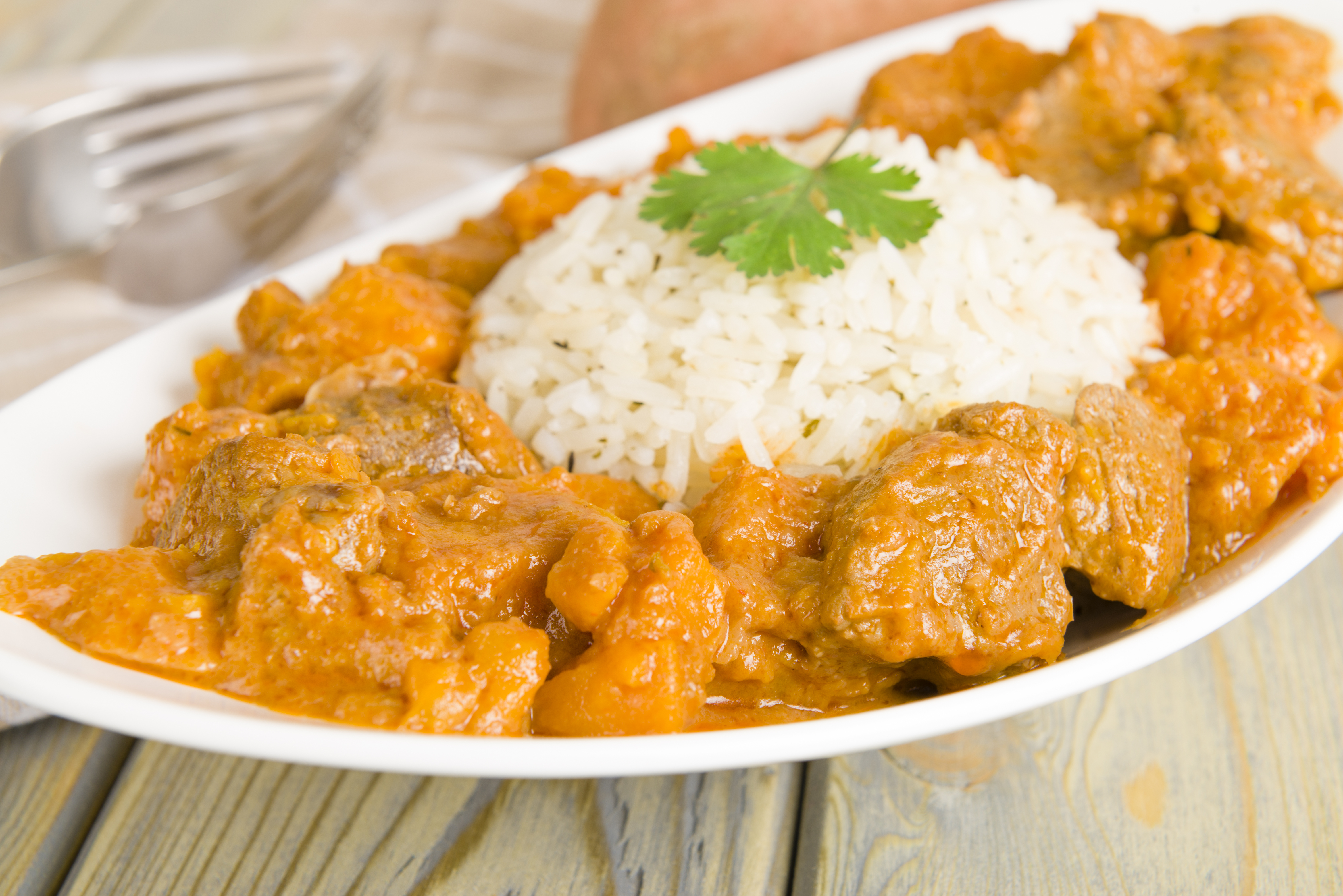 Lamb and sweet potato peanut stew served with white rice. Caribbean and West African dish.