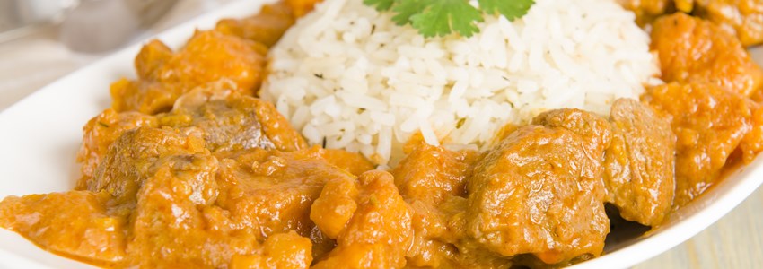 Lamb and sweet potato peanut stew served with white rice. Caribbean and West African dish.