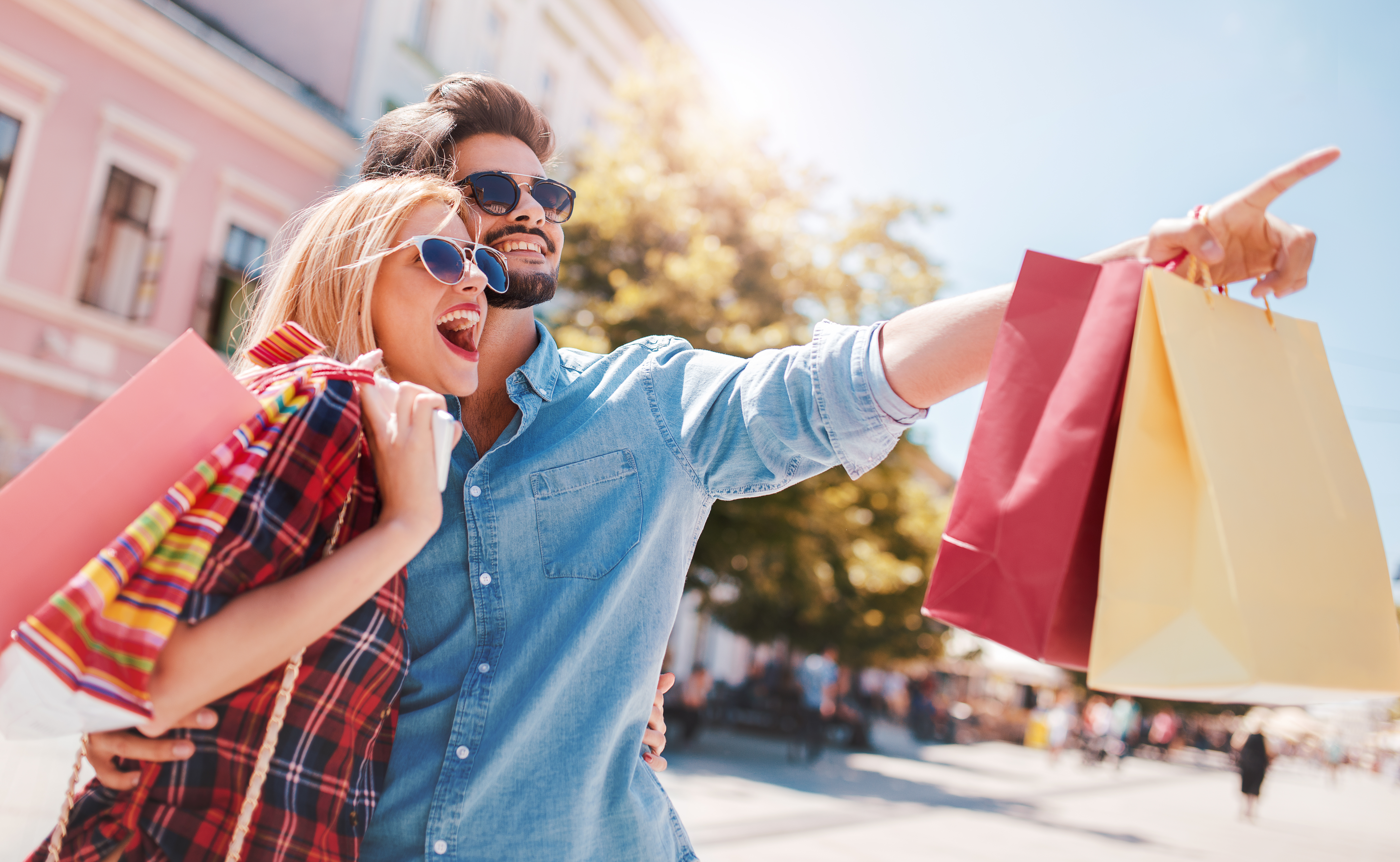 Shopping. Beautiful young couple enjoying in shopping, having fun in the city. Consumerism, love, dating, lifestyle concept