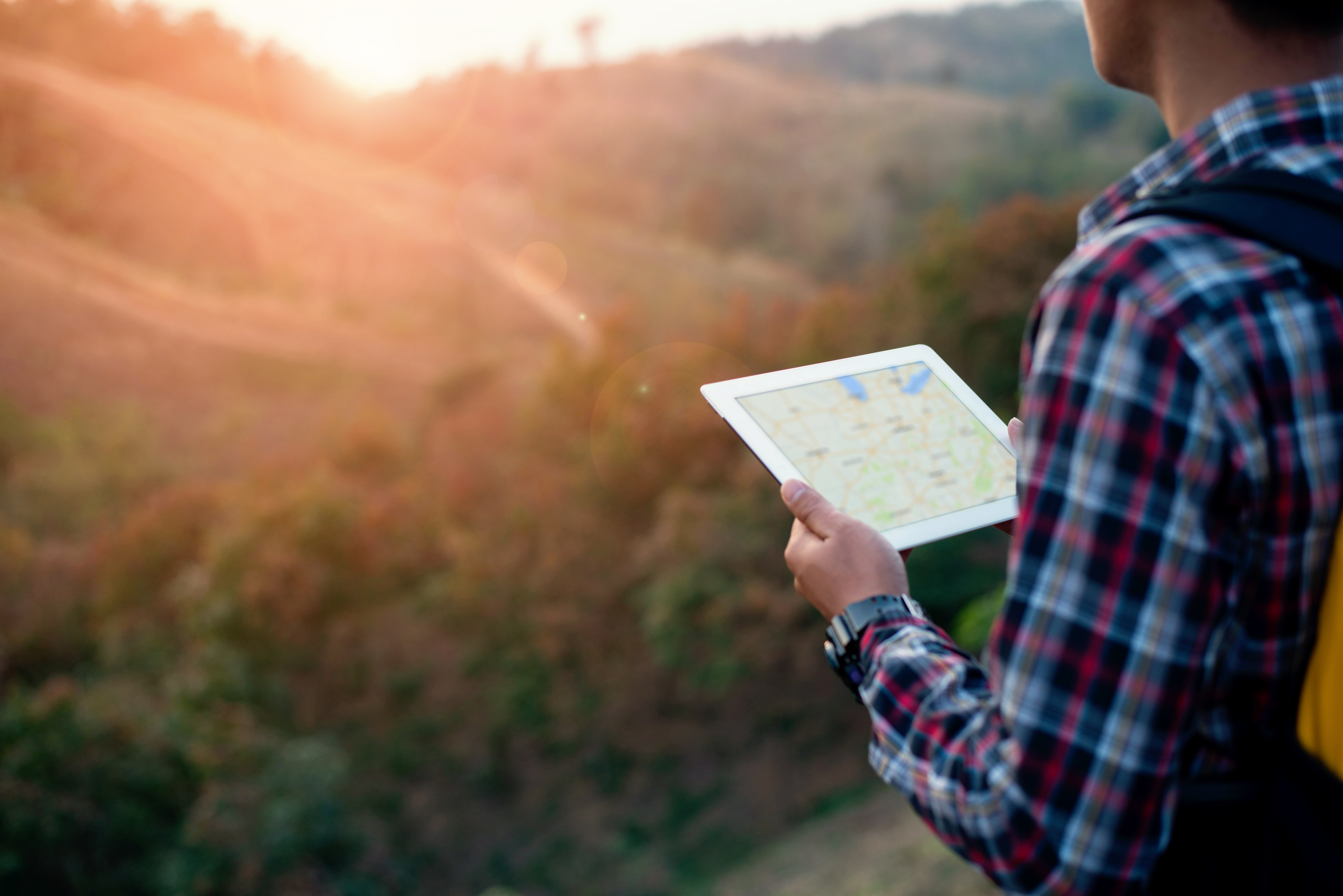 close up traveler man looking location on tablet,man reading mapclose up traveler man looking location on tablet,man reading map