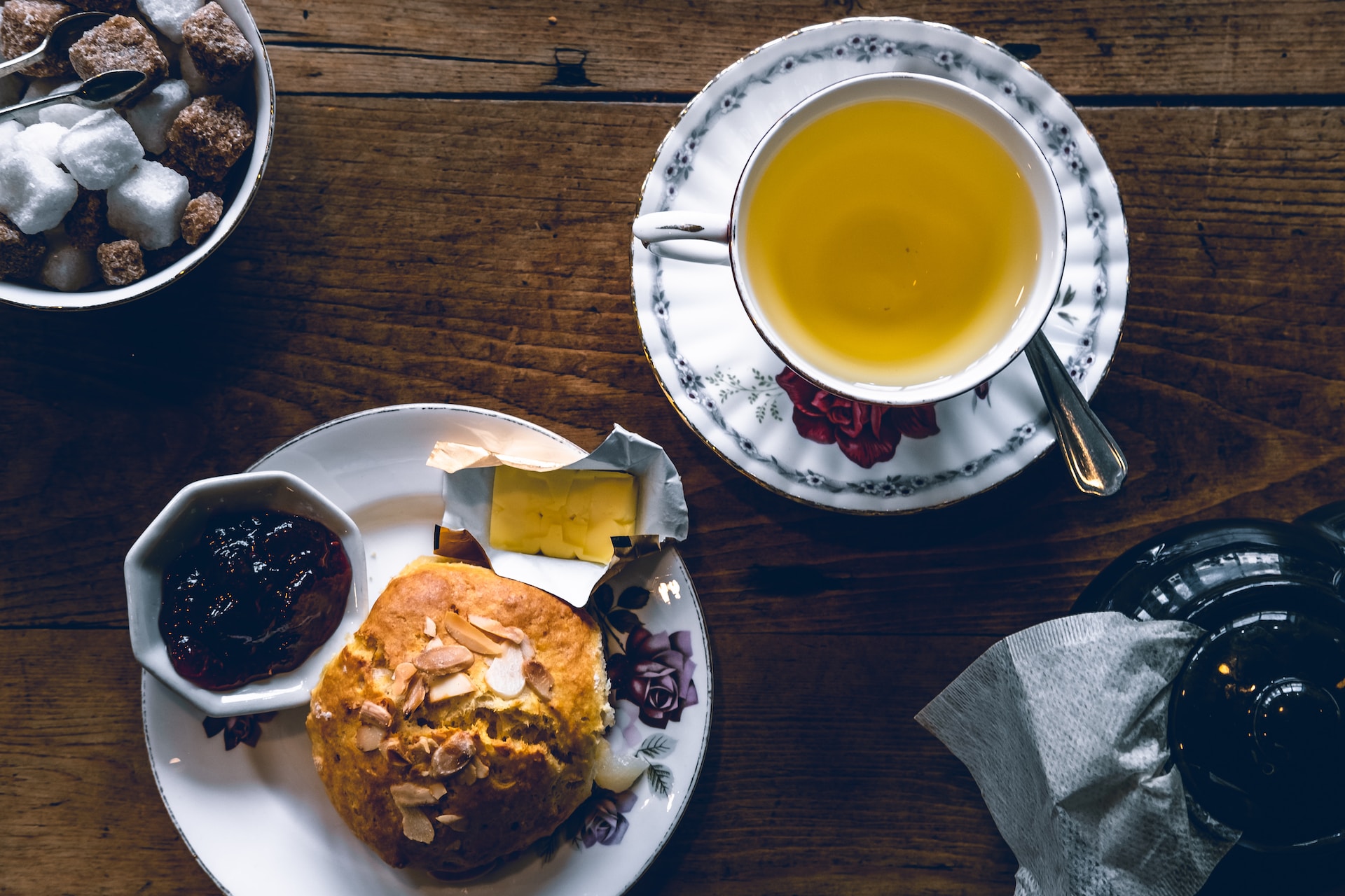 tea in cup and scone with jam and butter