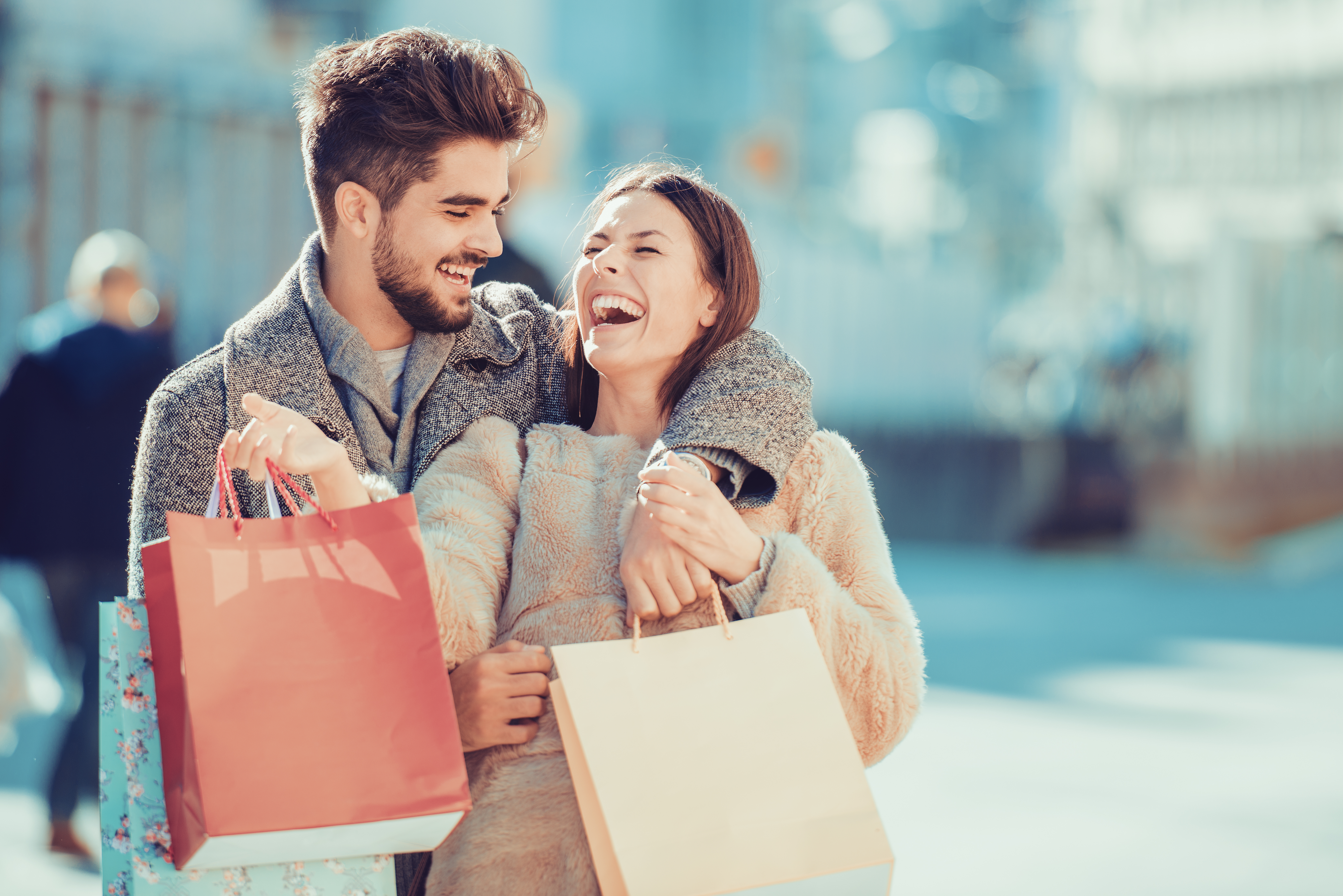 Beautiful young loving couple carrying shopping bags and enjoying together.