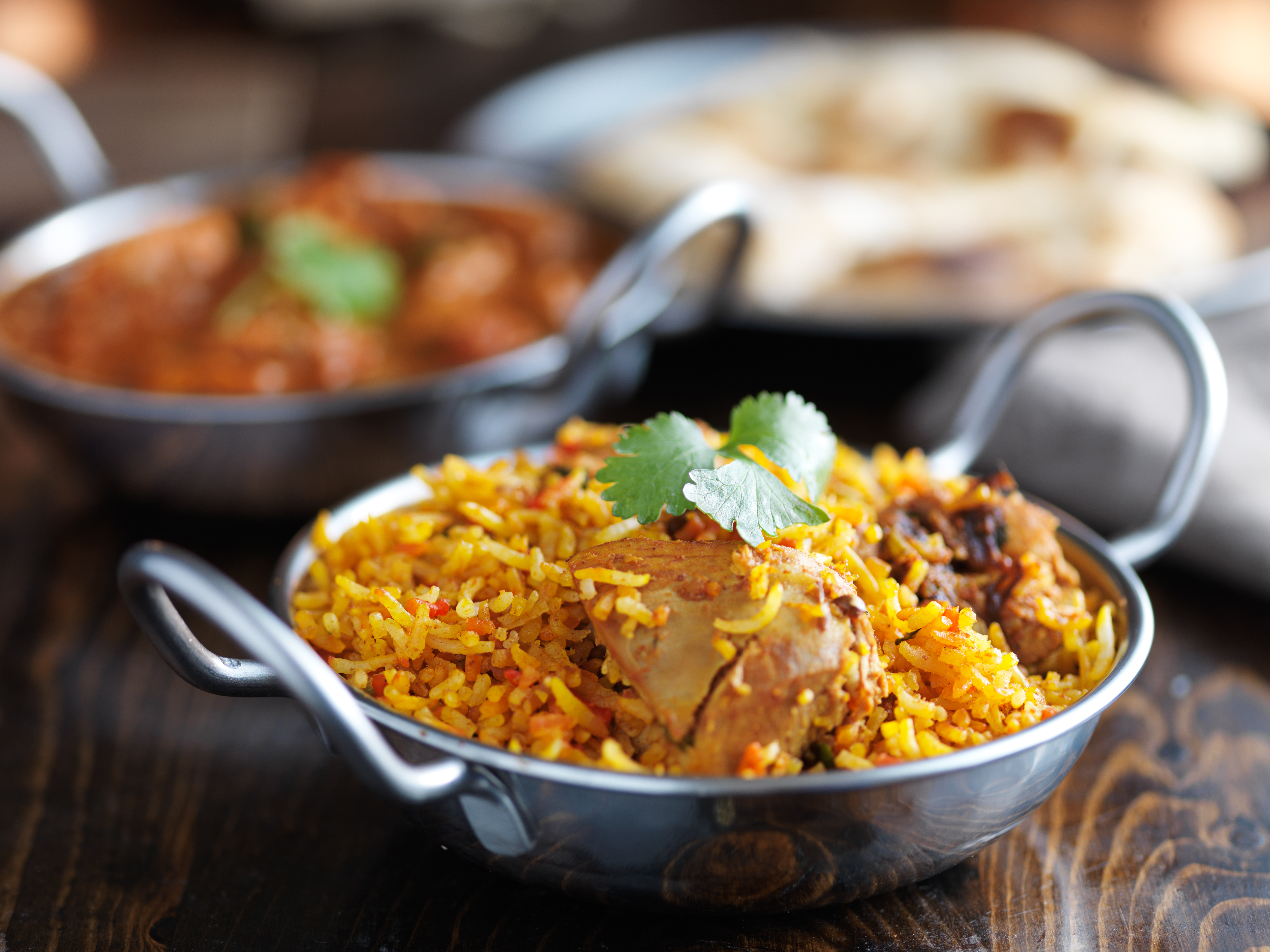 balti dish with indian chicken biryani and curry in the background