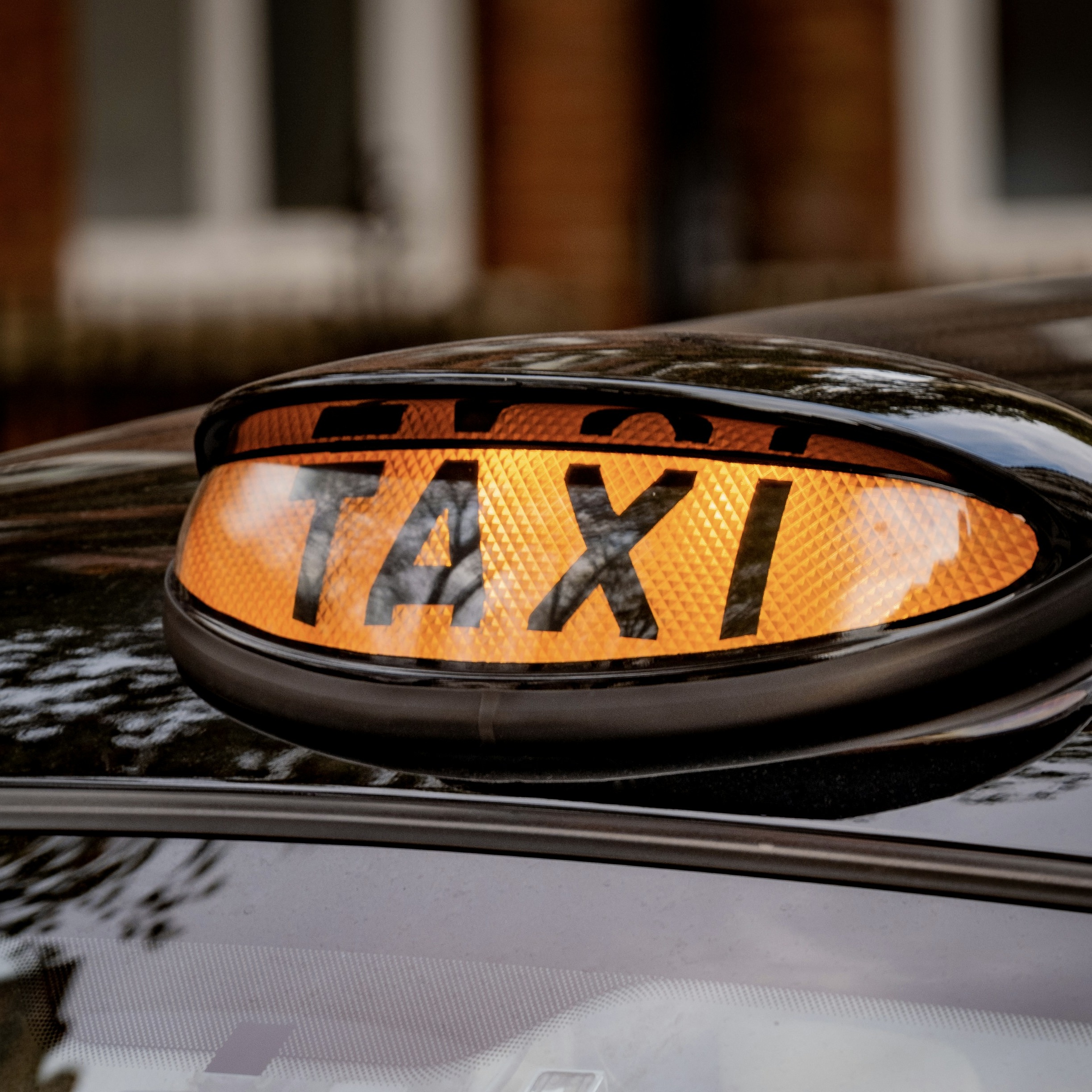 Close up of a black cab illuminated taxi sign