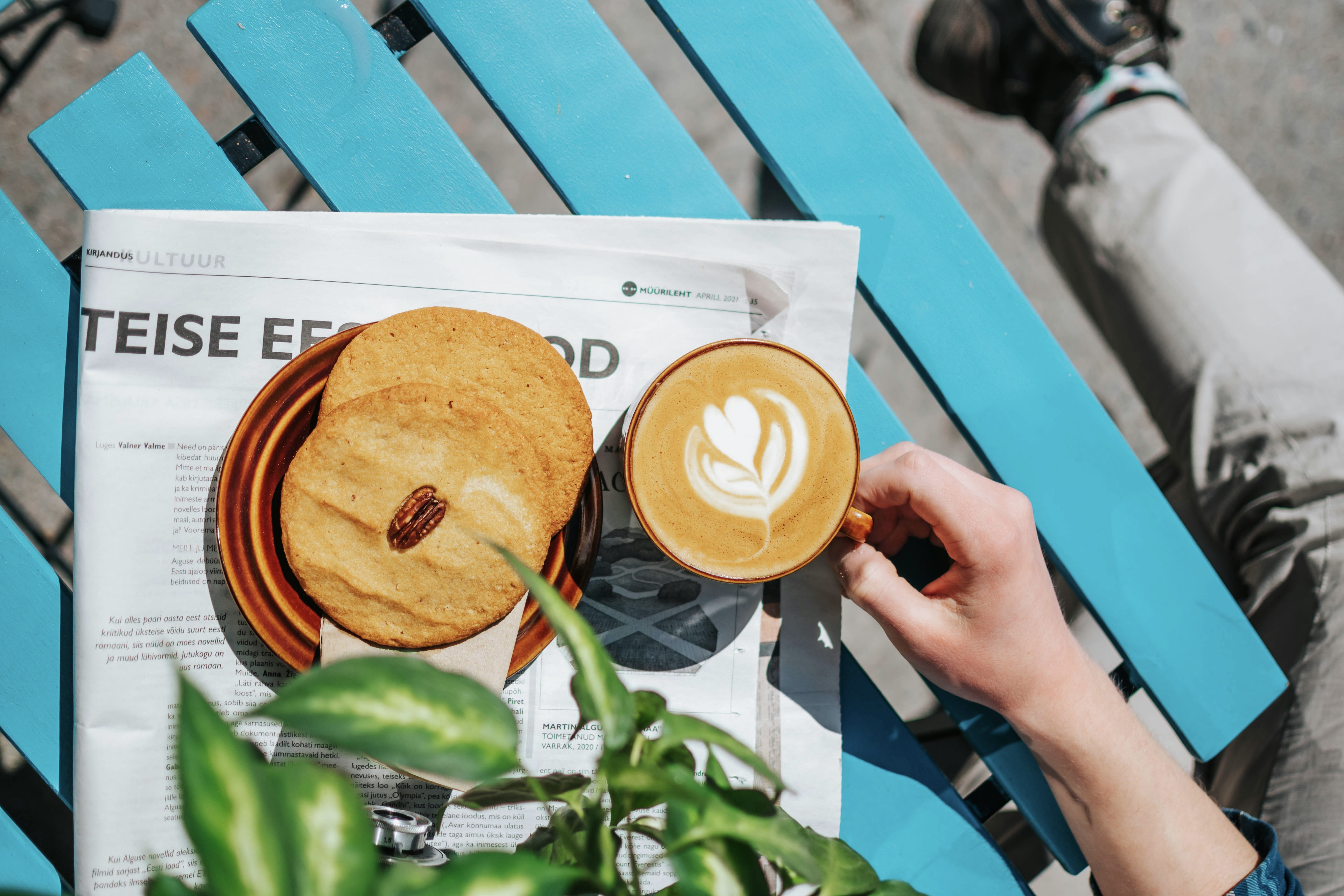 coffee and a newspaper on a blue cafe table