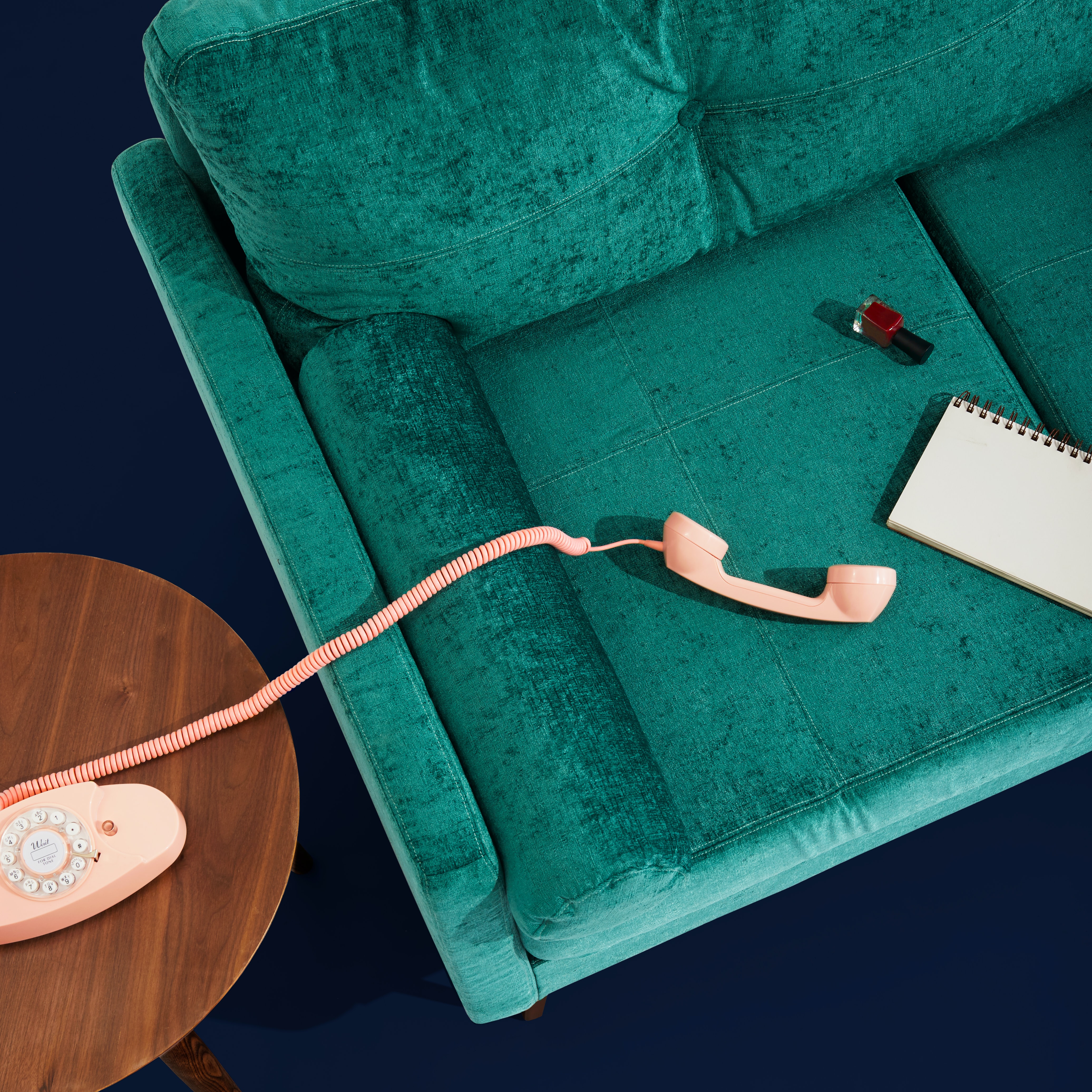 pink phone on a blue velvet couch