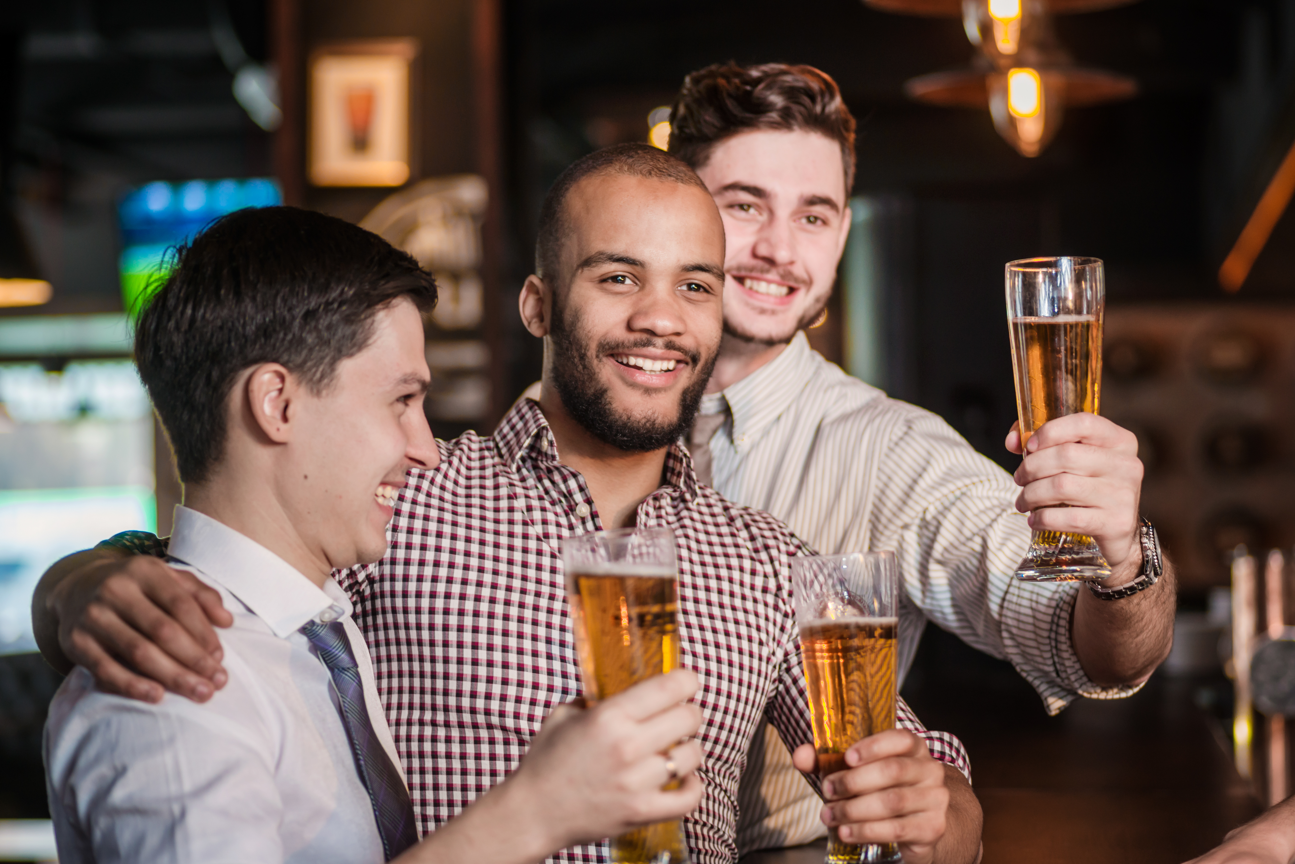 Three cheerful friend clink beer