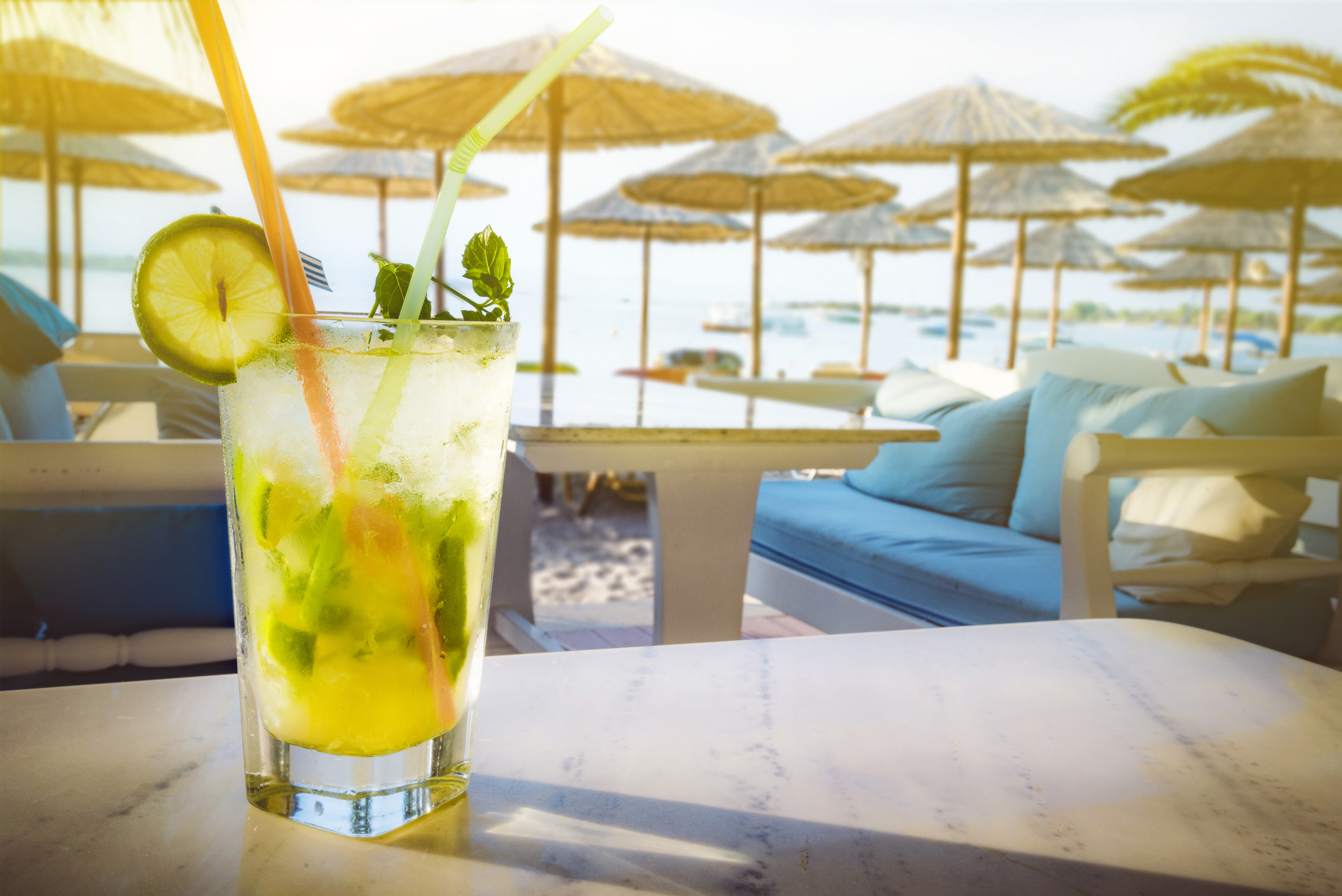 Mojito drink on the stone table. Beach bar background.