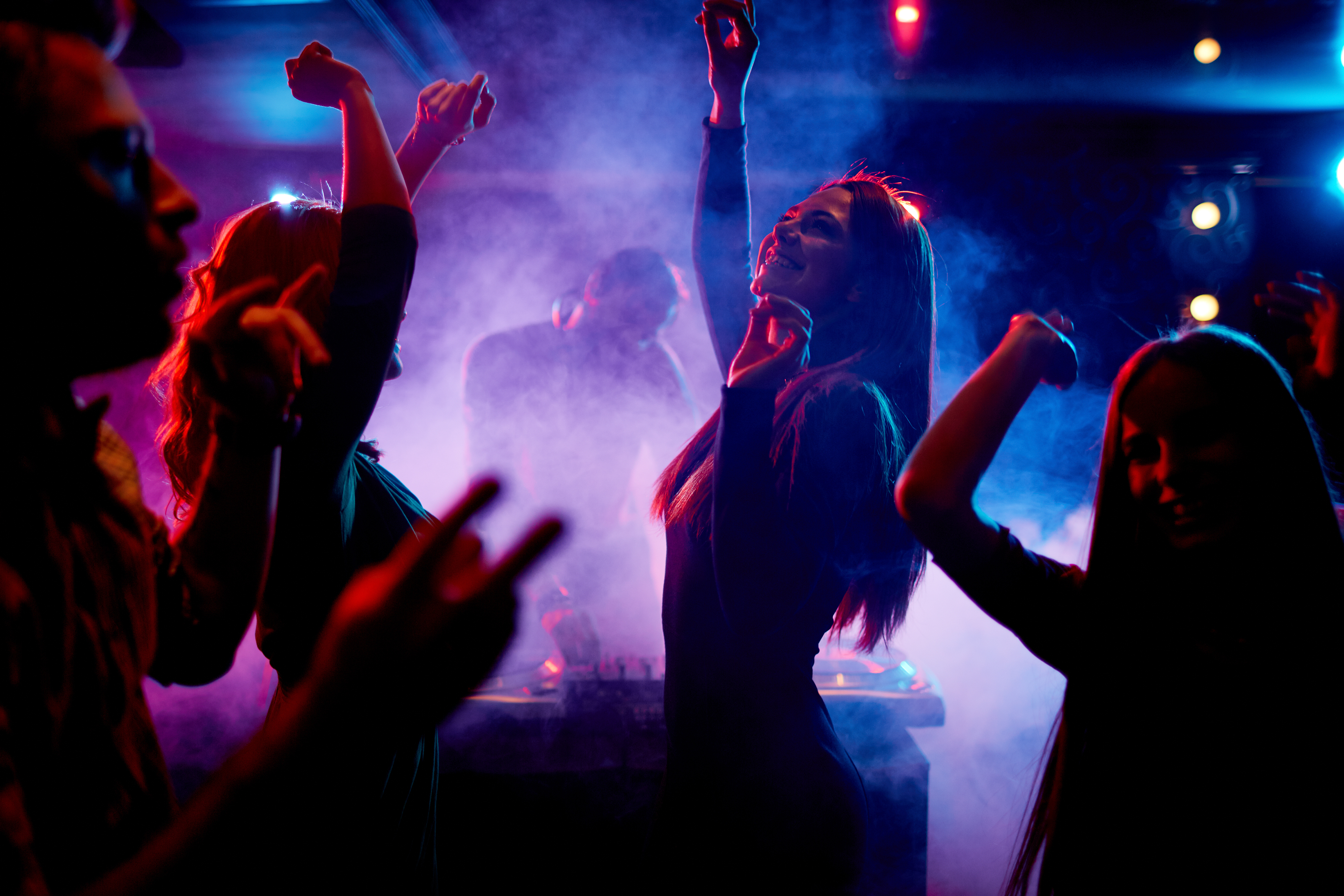 Group of dancing young people enjoying night in club