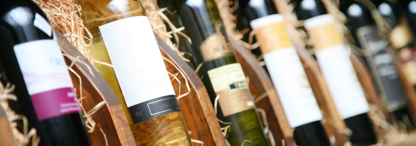 Closeup shot of wineshelf. Bottles lay over straw.