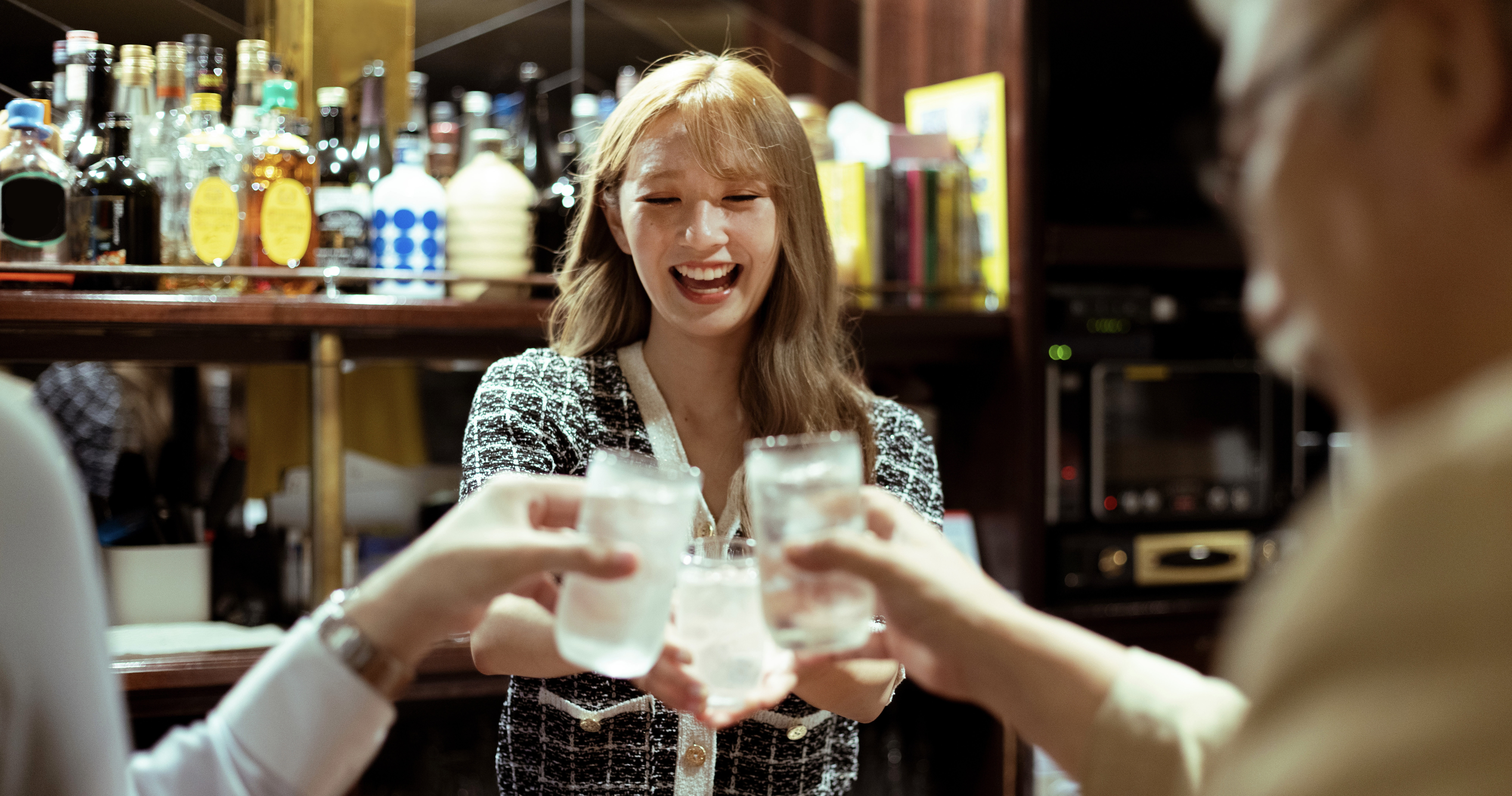 Young woman serving liquor at the counter bar