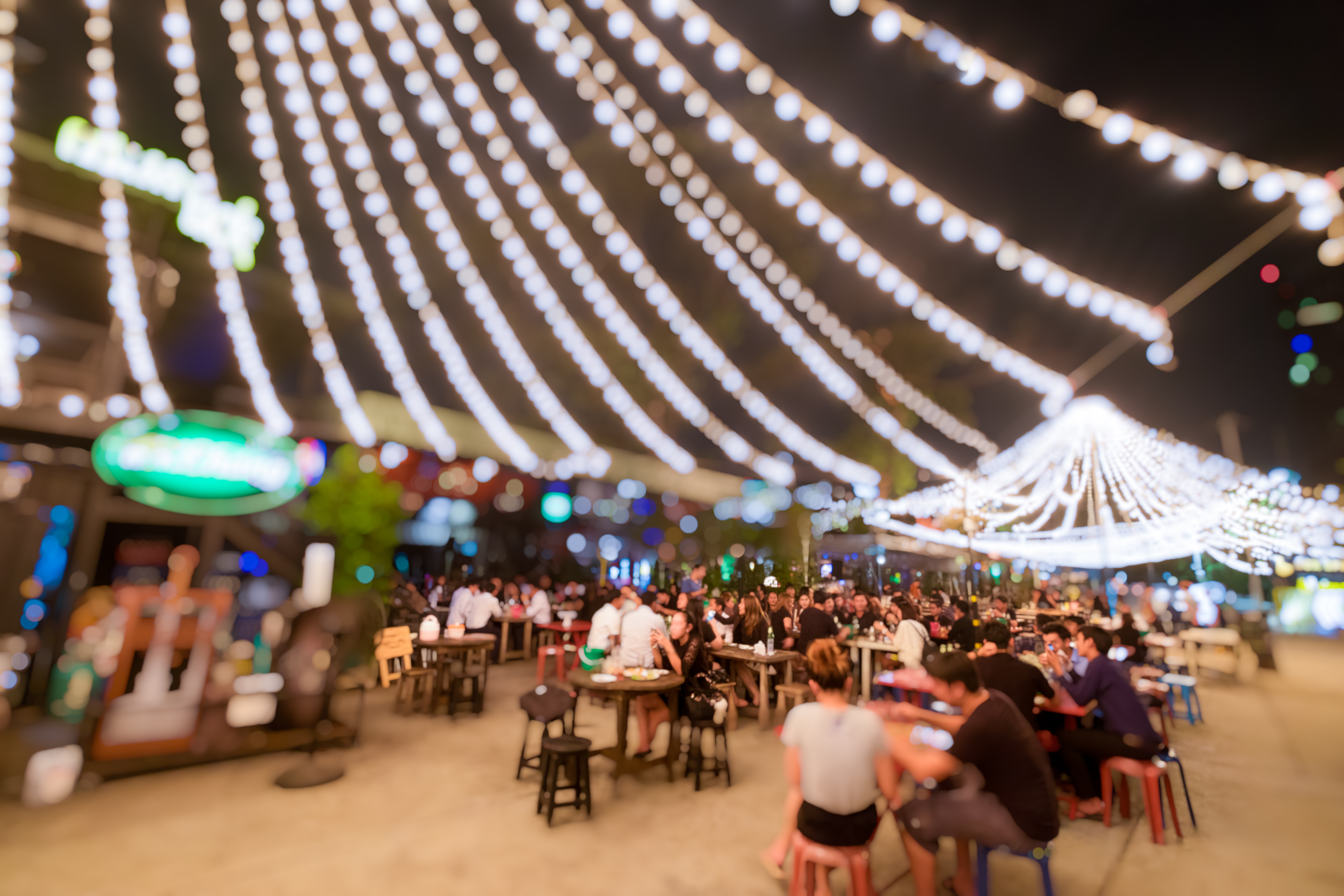 Bokeh background of Street Bar beer restaurant, outdoor in asia, People sit chill out and hang out dinner and listen to music together in Avenue, Happy life ,work hard play hard