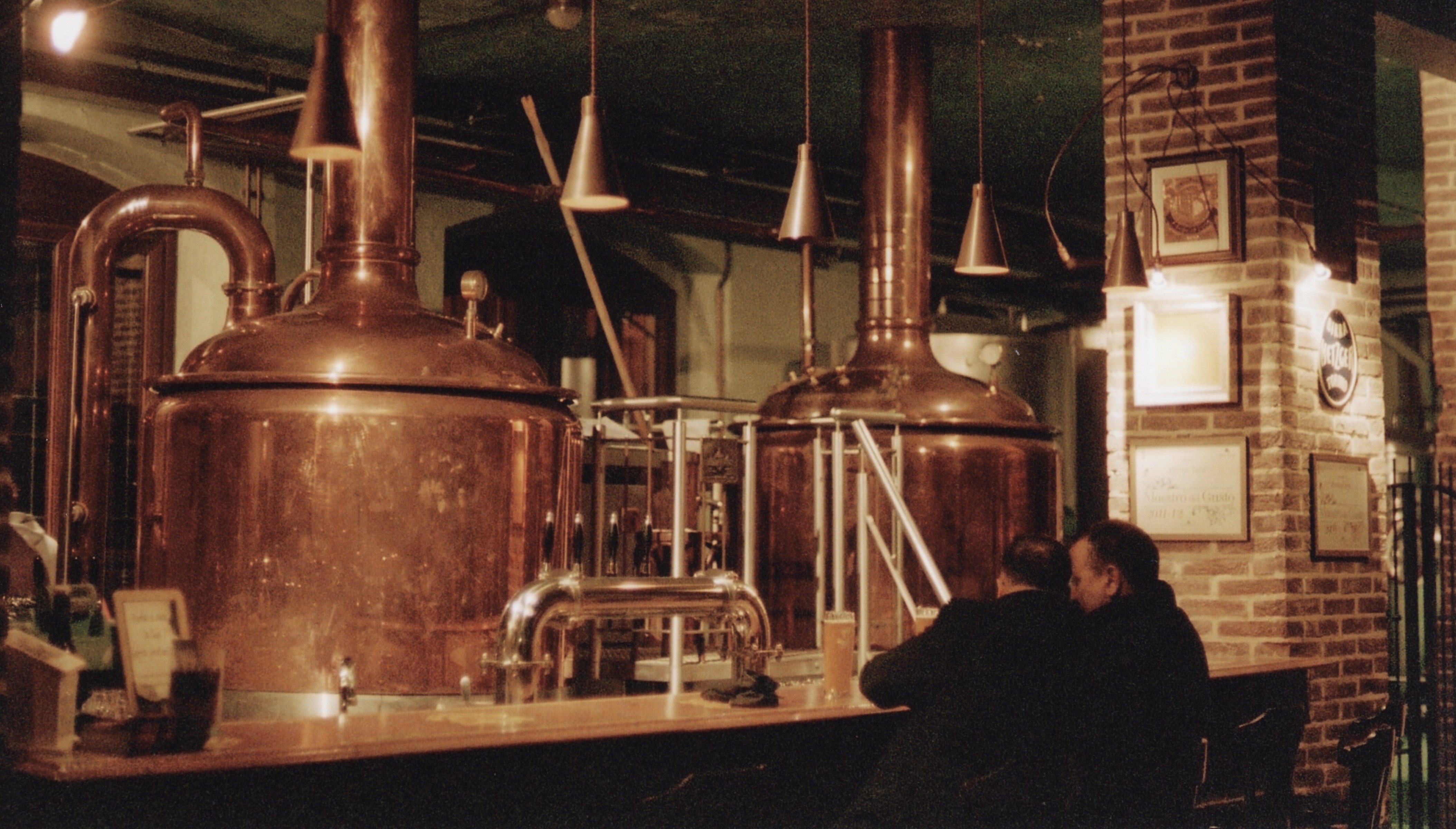 two man sitting in front of brewing equipment at Birrificio Torino