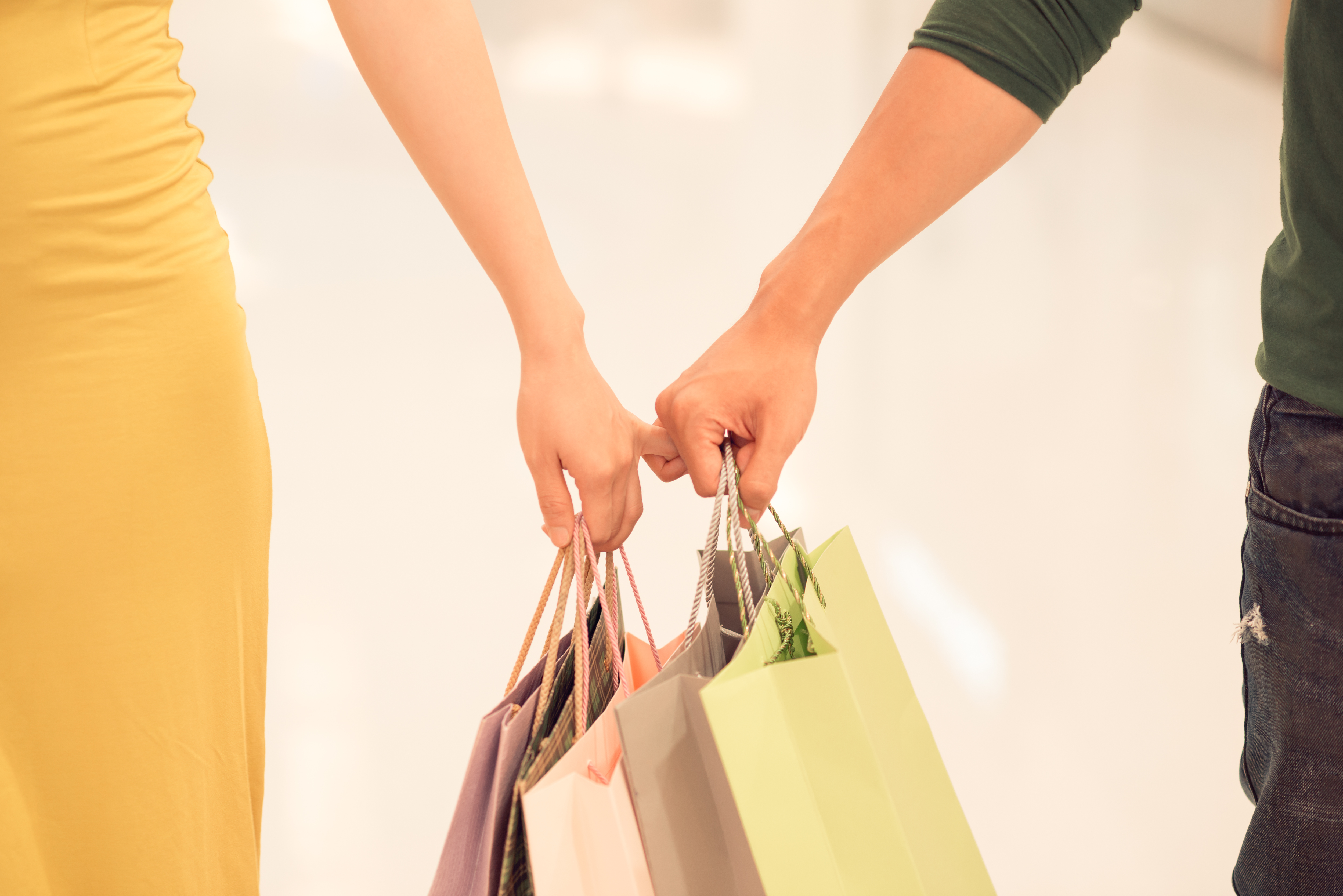 Close-up of hands holding shopping bags