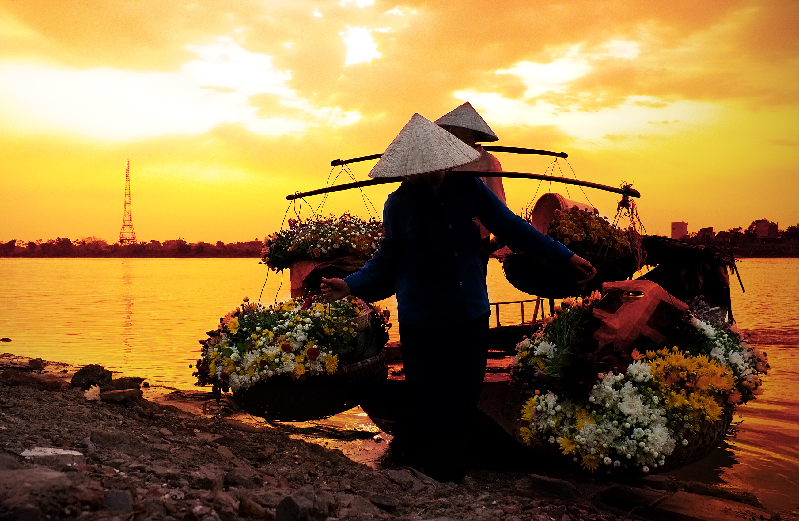 women selling flowers on a boat in the early morning