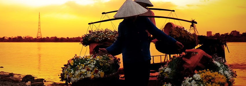 women selling flowers on a boat in the early morning