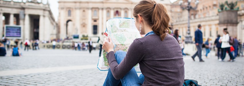 Woman looking at a map at St Peter's square in the Vatican City in Rome