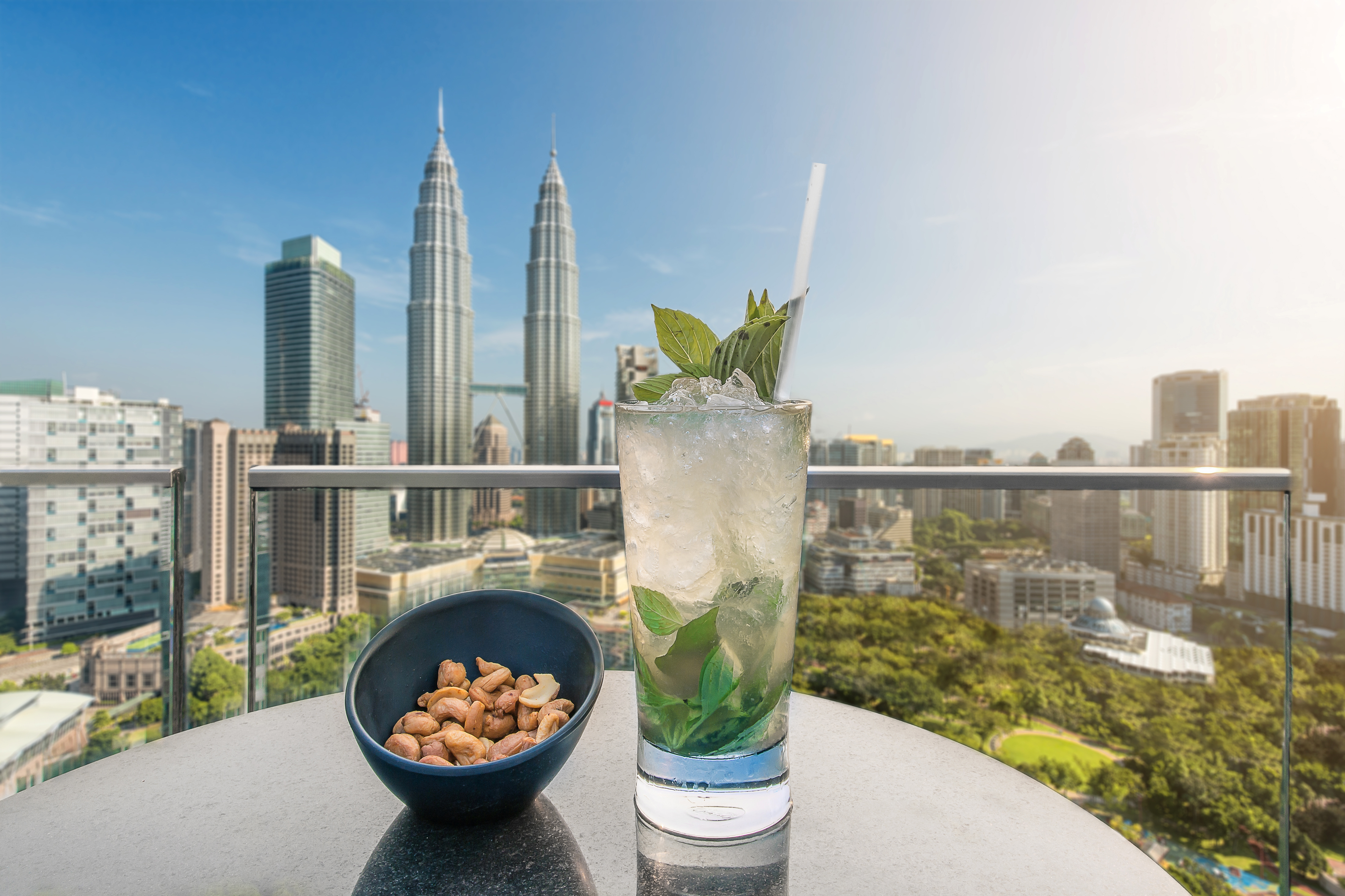 Mojito cocktail and cashews on table in rooftop bar at Kuala Lumpur, Malaysia