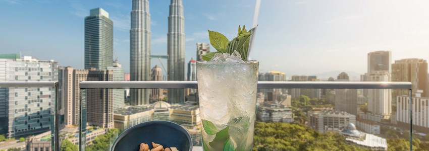 Mojito cocktail and cashews on table in rooftop bar at Kuala Lumpur, Malaysia