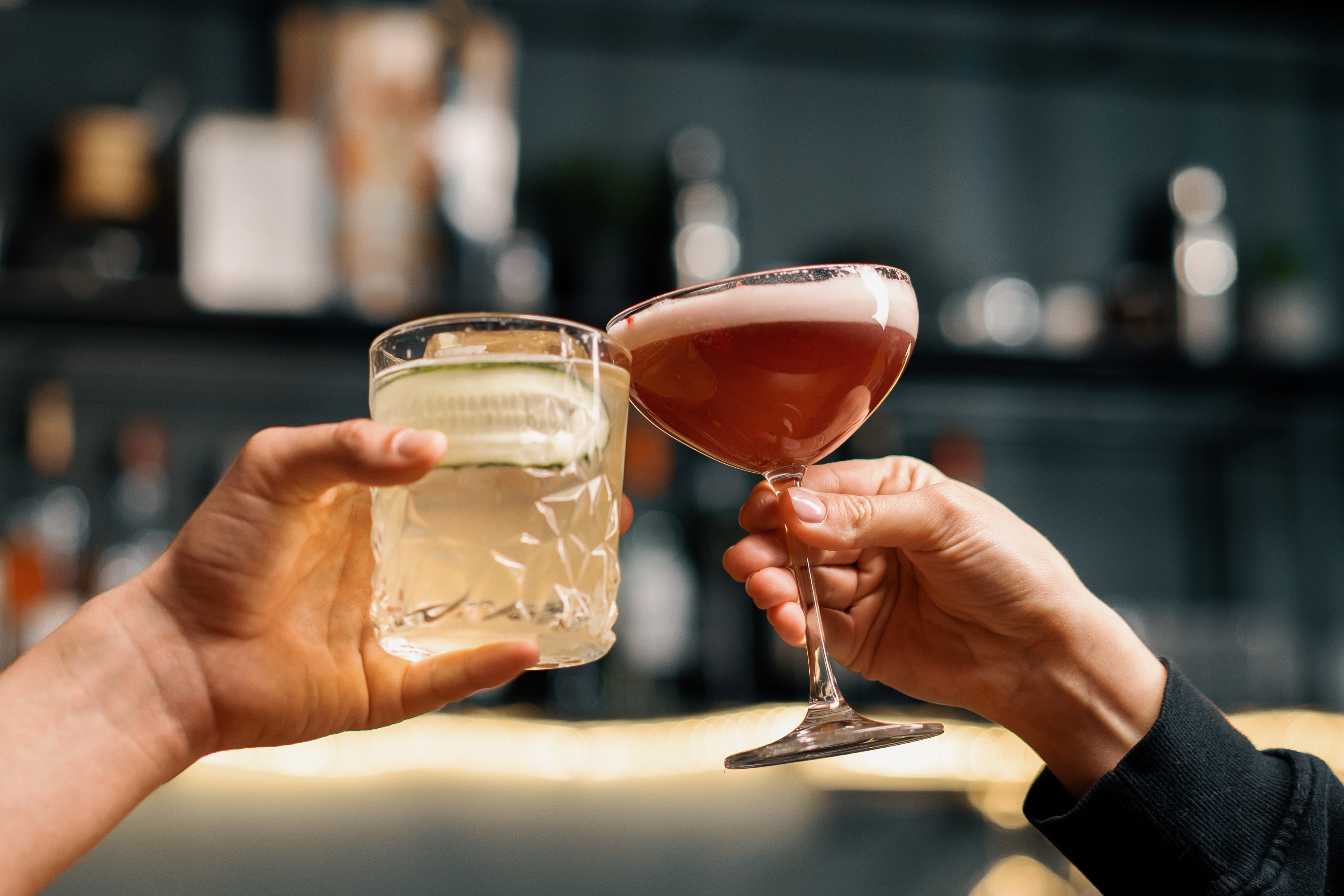Close up of two people cheering cocktails in bar or disco club drinks and cocktails concept