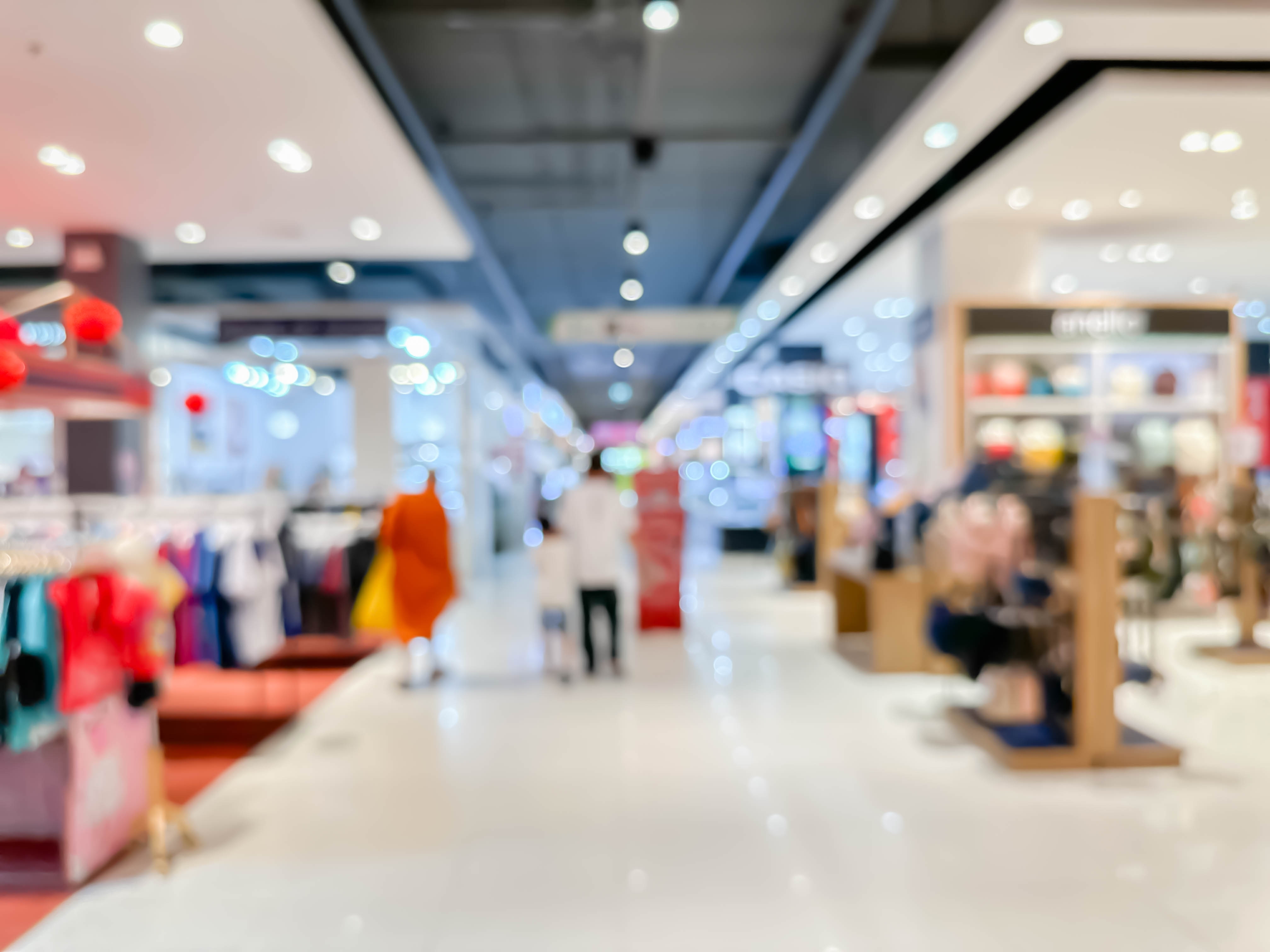 Blurred image of people walking and shoping at atmosphere of  a leading shopping center decorated in a modern way background