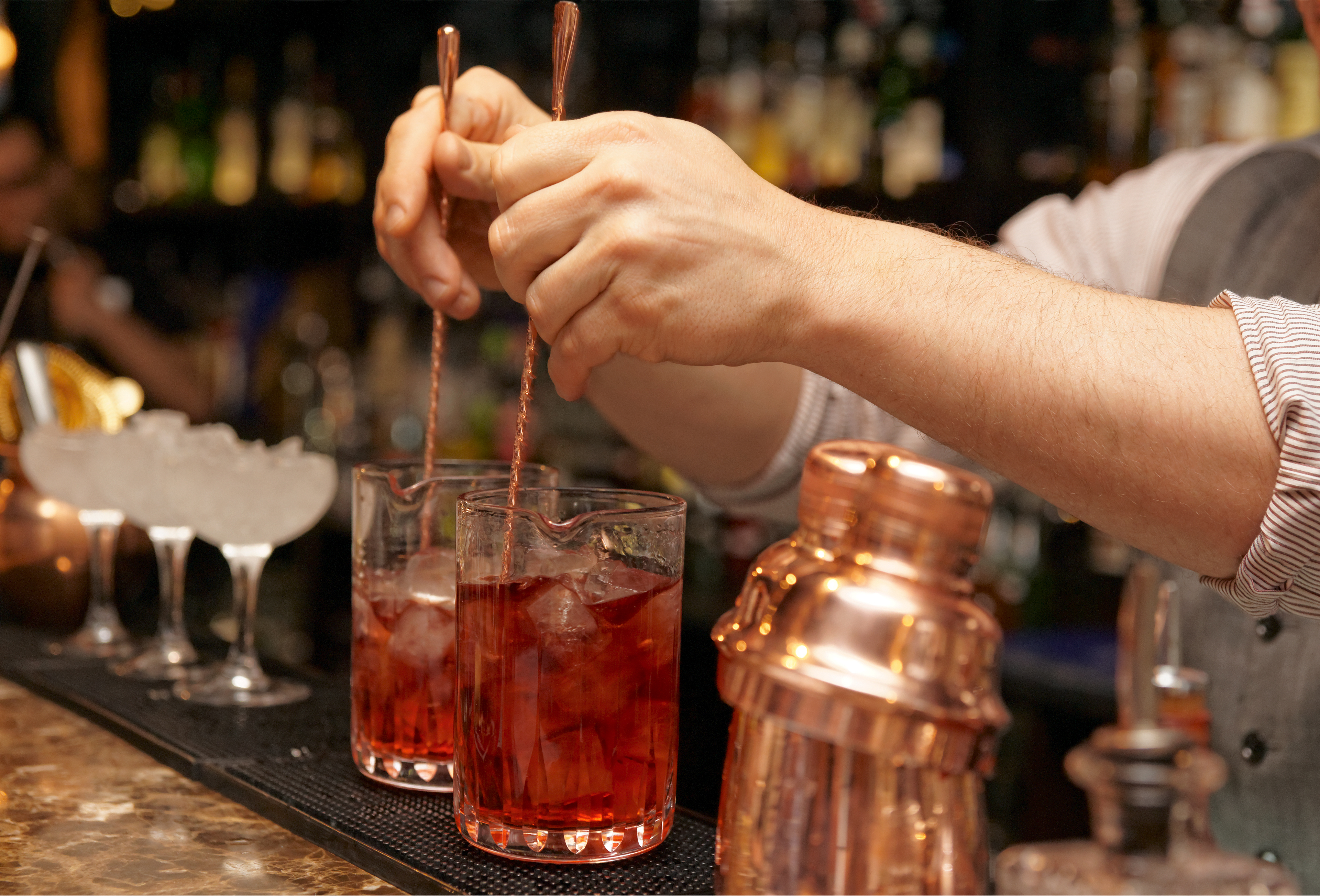 Bartender is stirring cocktails on bar counter