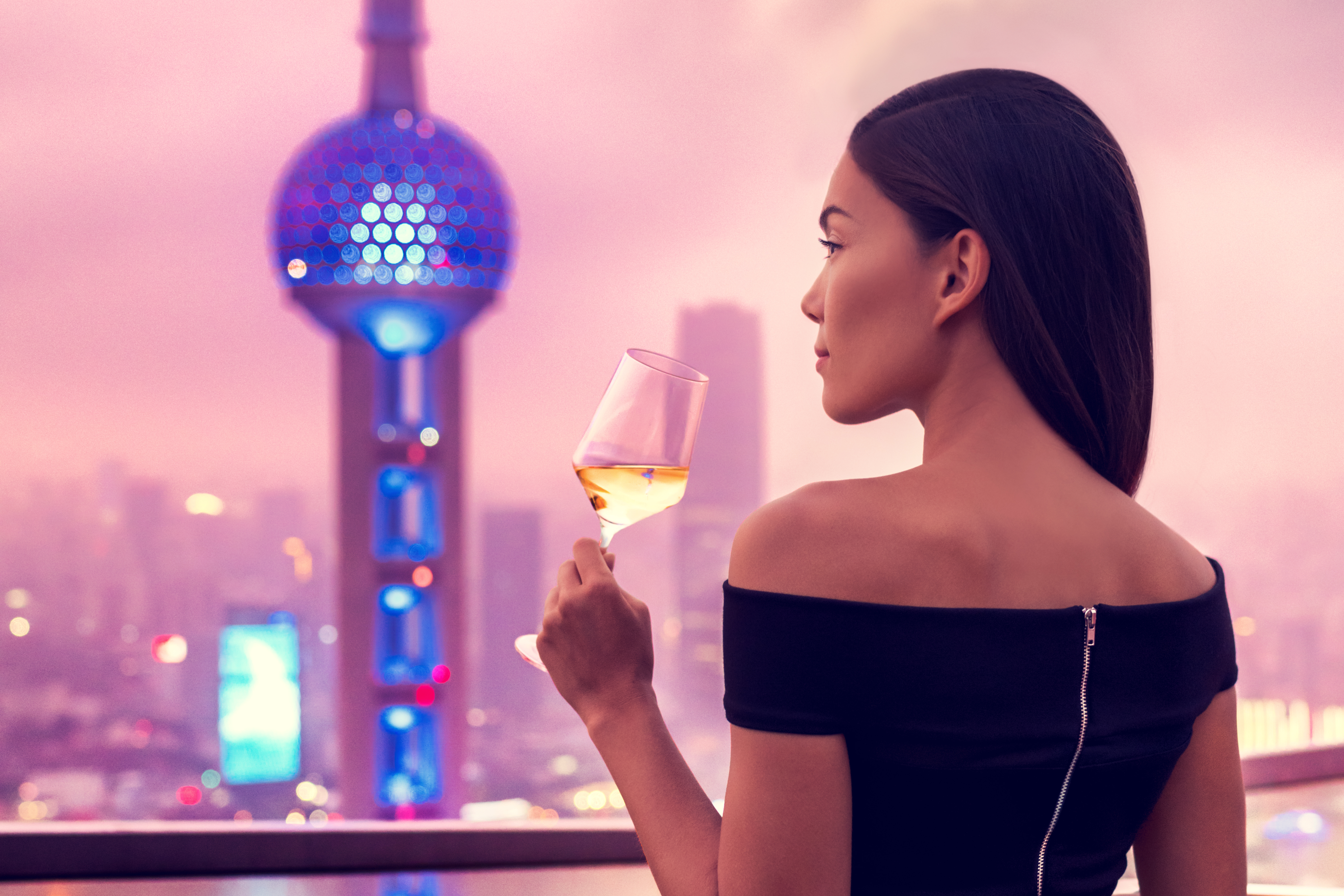 Woman with drink overlooking Oriental Tower