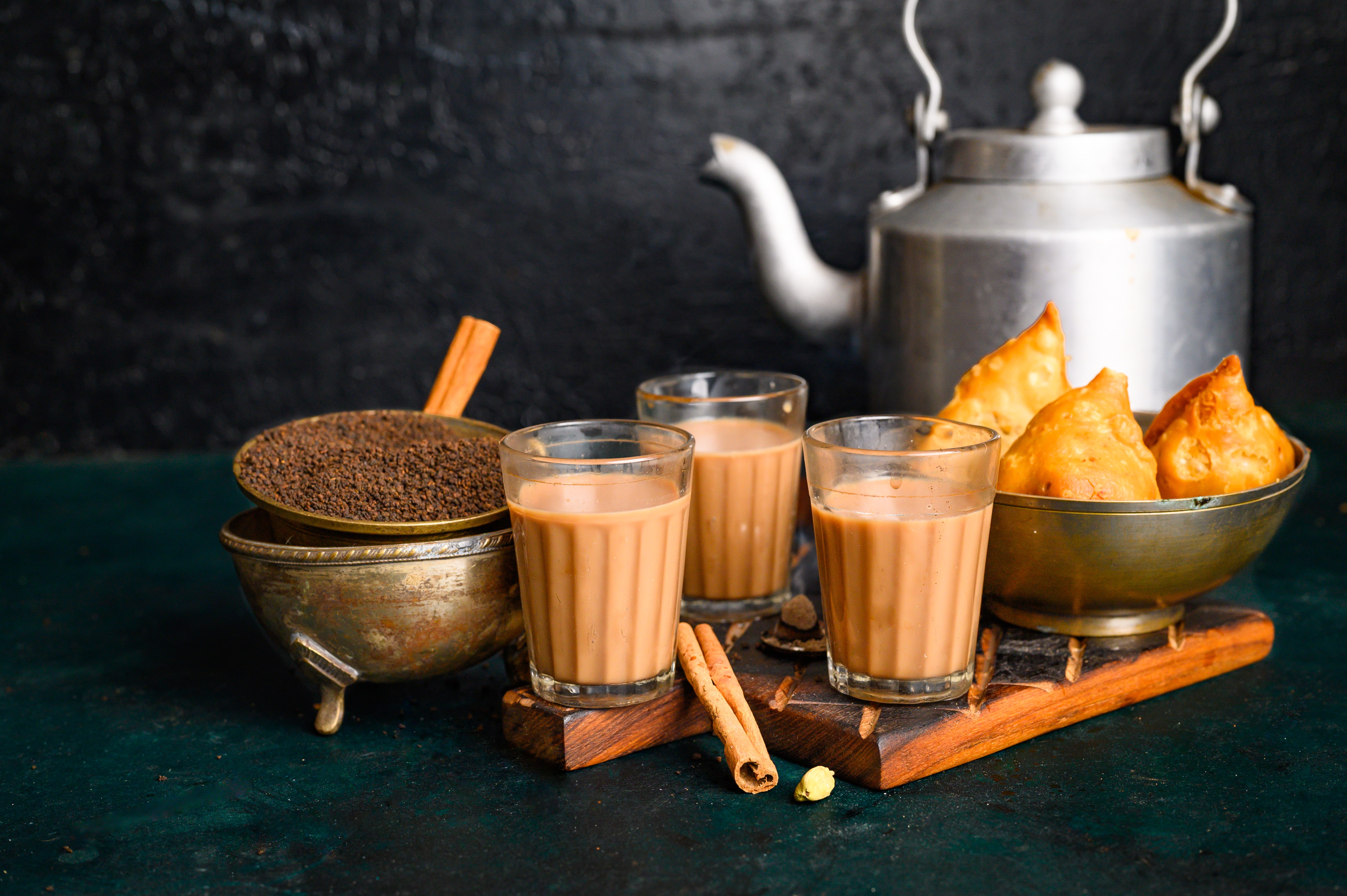 Indian masala chai spice tea with kettle, samosa