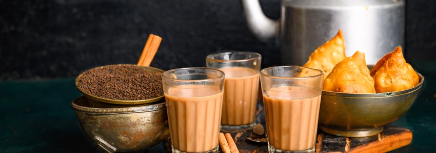 Indian masala chai spice tea with kettle, samosa