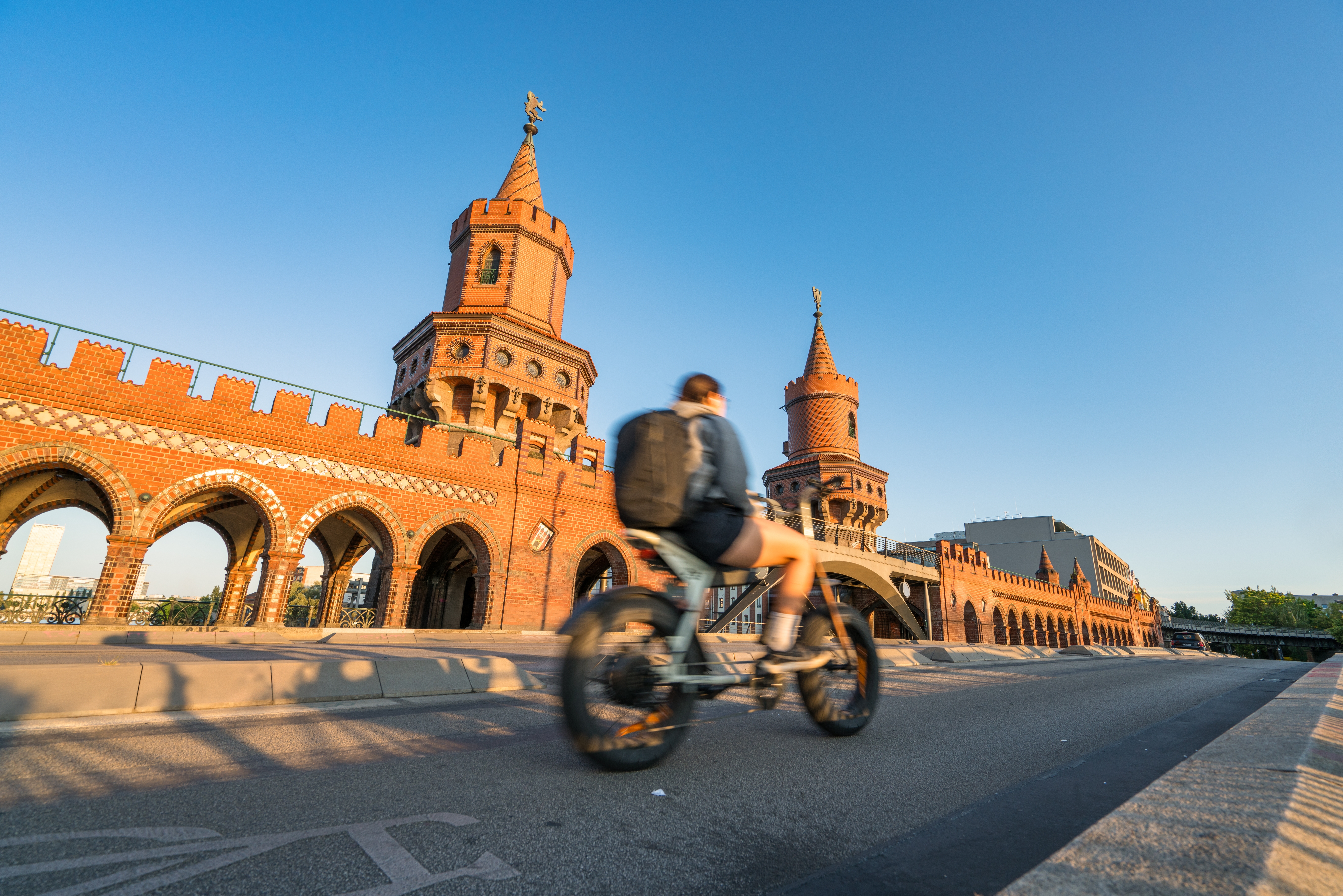 Oberbaum Bridge with soft sunset light and blurry cyclist in motion in Berlin