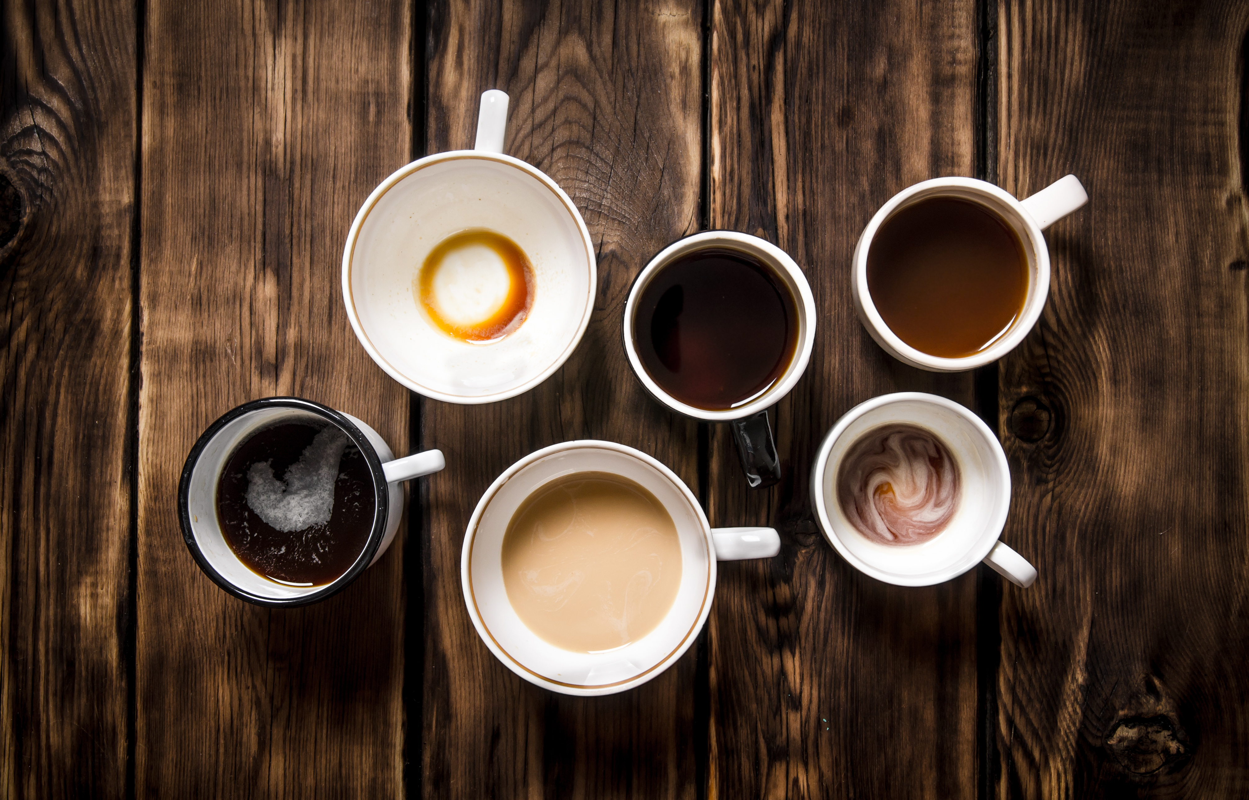 Set empty and full cups of coffee. On black rustic background.