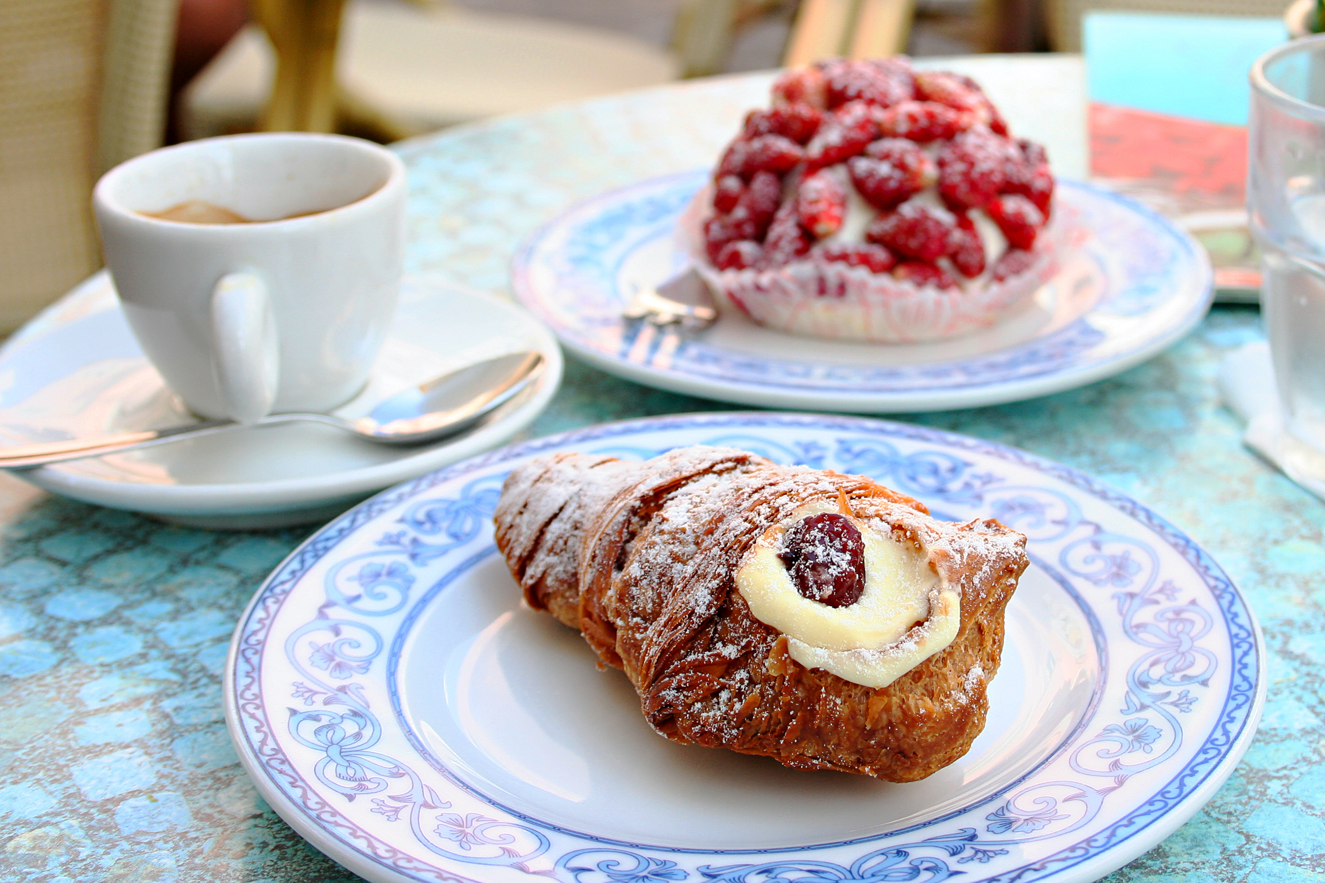 Tradition cake of region Campania Code di Aragosta on white blue plate with cup of coffee and strawbarry cake background in Sant Angelo, Ischia