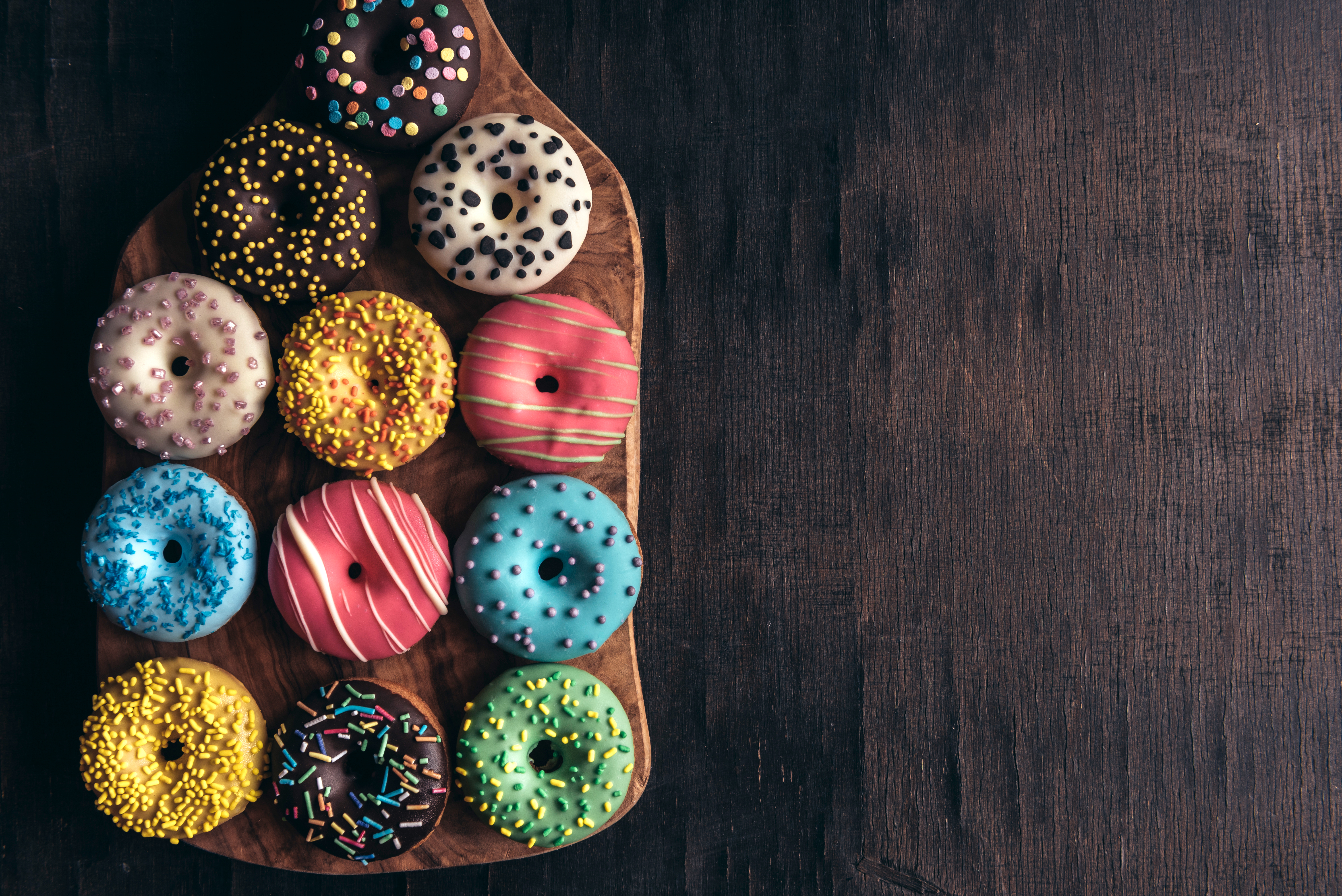 Colourful Donuts on wooden plate