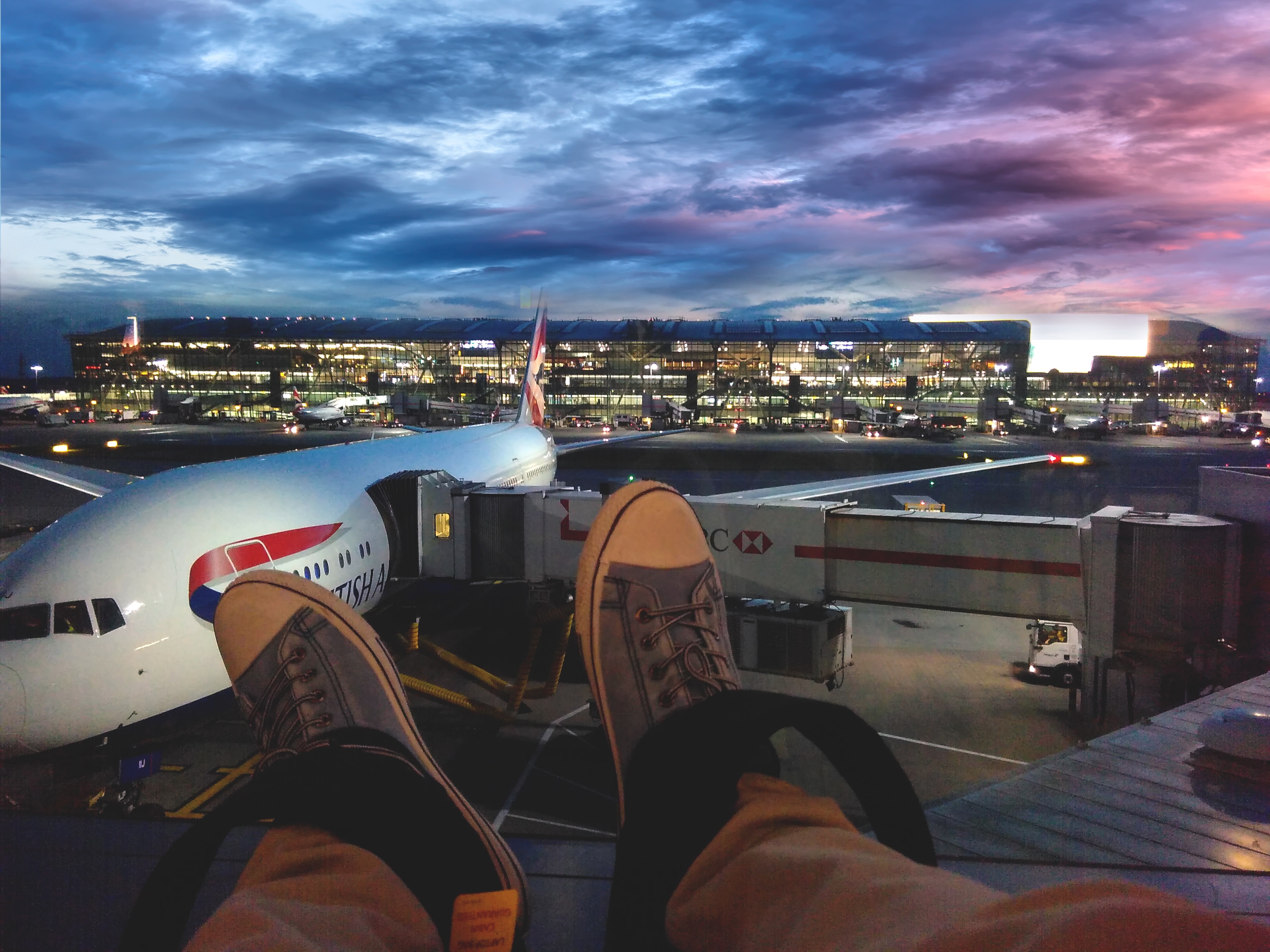 Person in gray shoes in front of London Stansted Airport