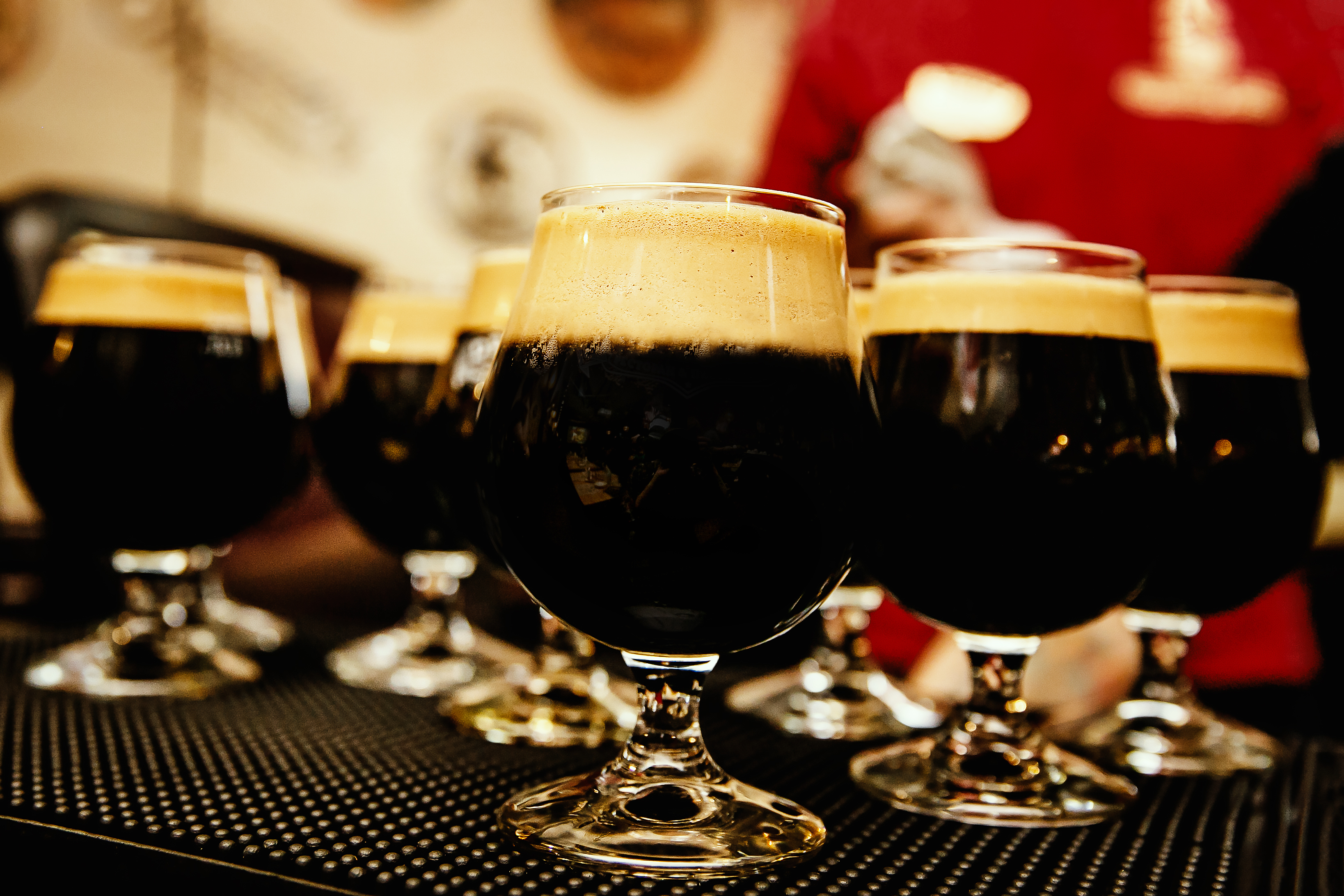 Glasses of dark beer with froth in bar