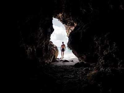 man in front of cave in curacao - Bruno van der Kraan/Unsplash