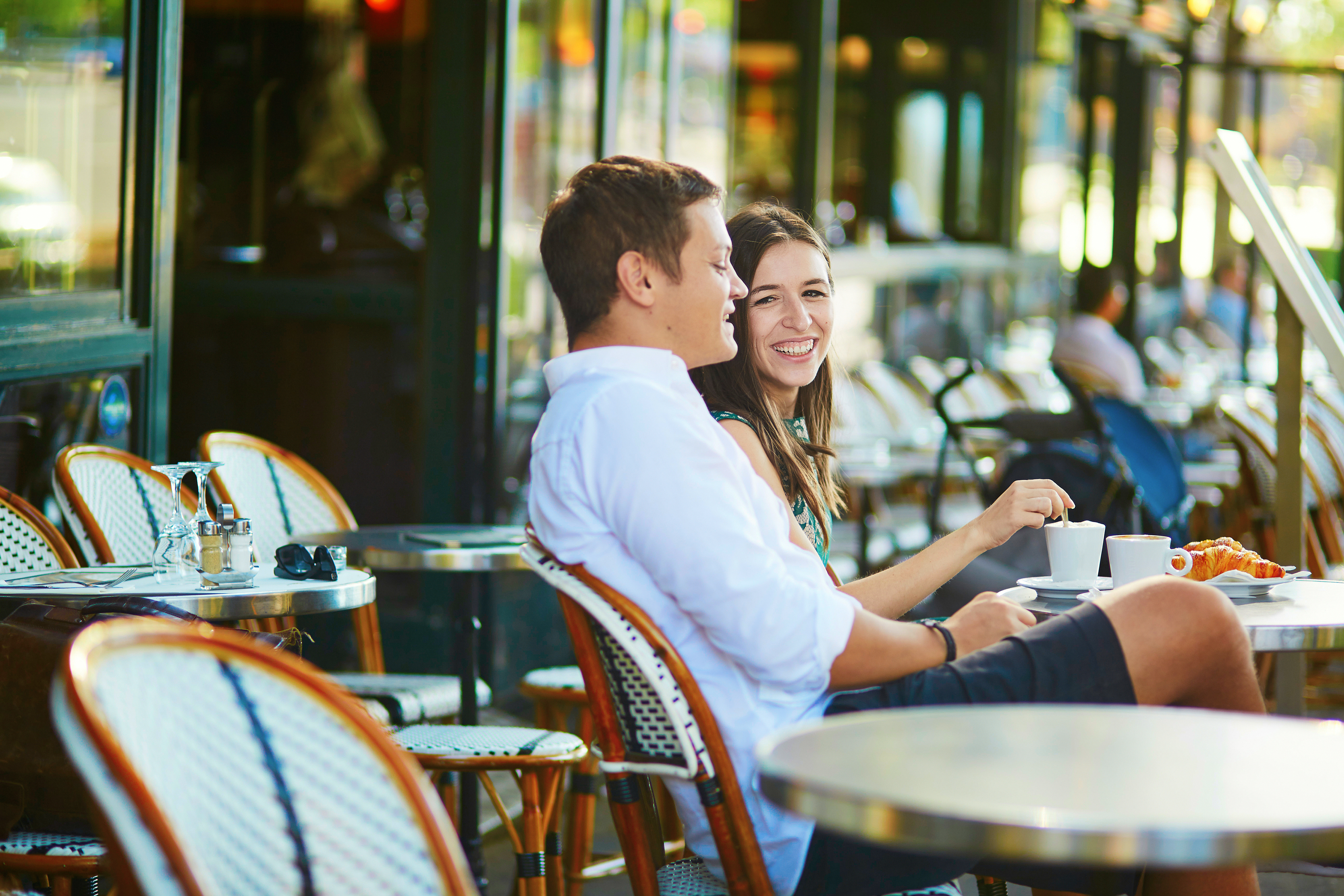 Couple sitting in a cozy outdoor cafe in Paris, France