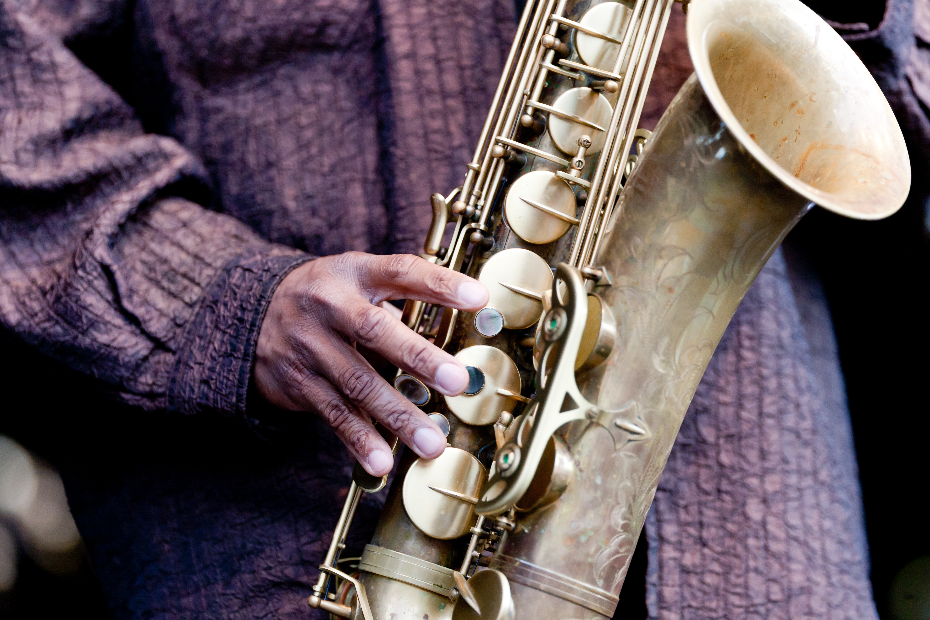 Hand of musician playing jazz saxophone during live performance on stage