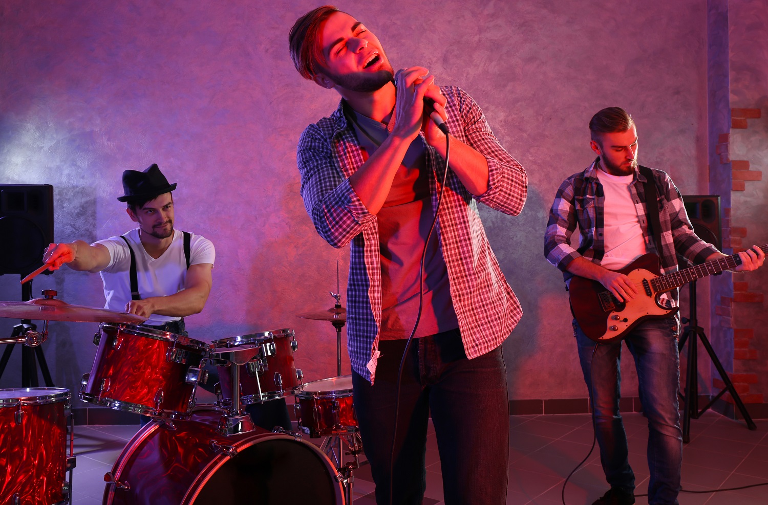 Musicians playing musical instruments and singing songs in a studio