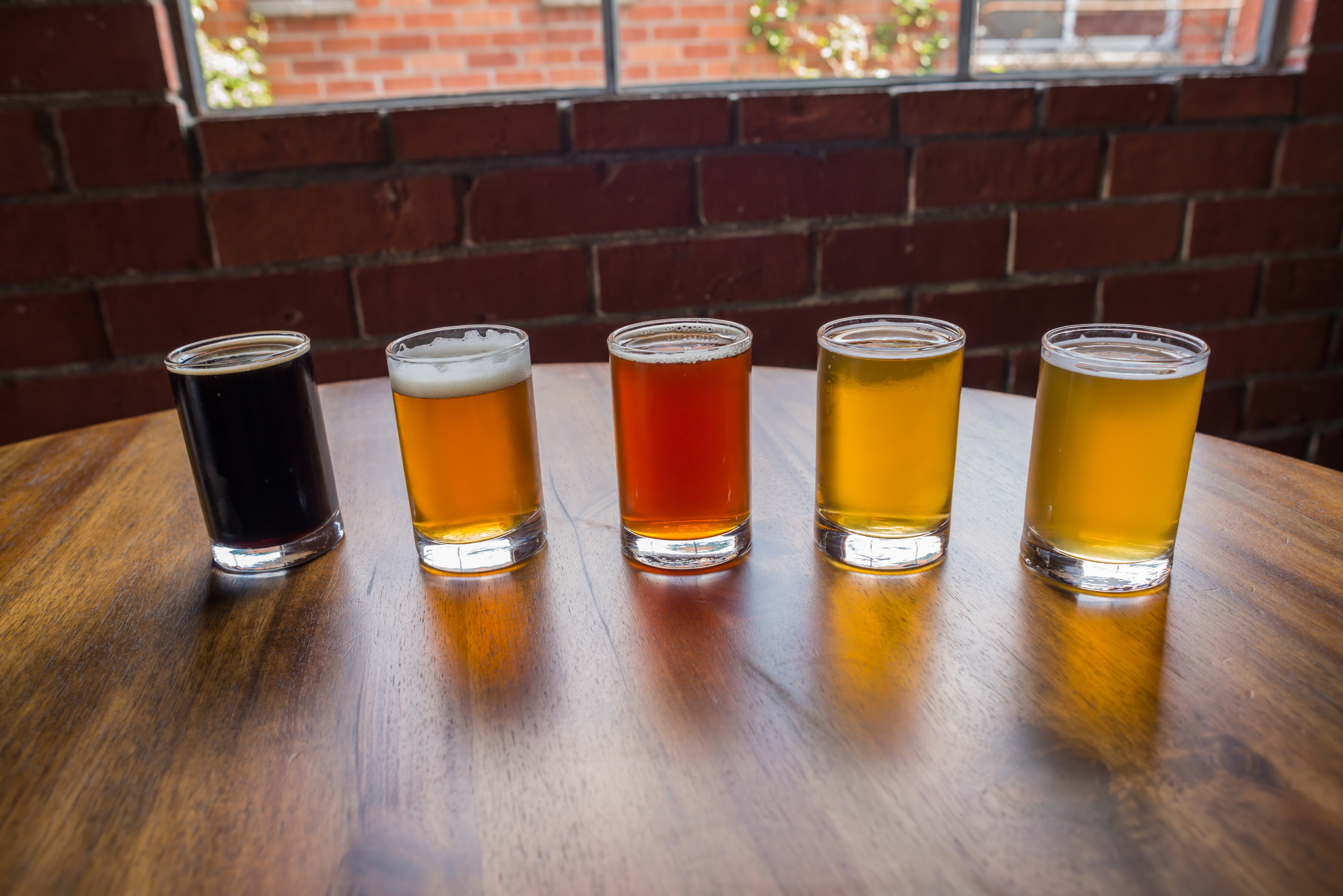 Beer sampler on a table by a window in an industrial looking space