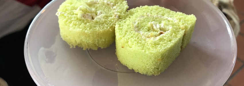 Two pieces of pandanus flavor roll cake, yam roll, jam roll