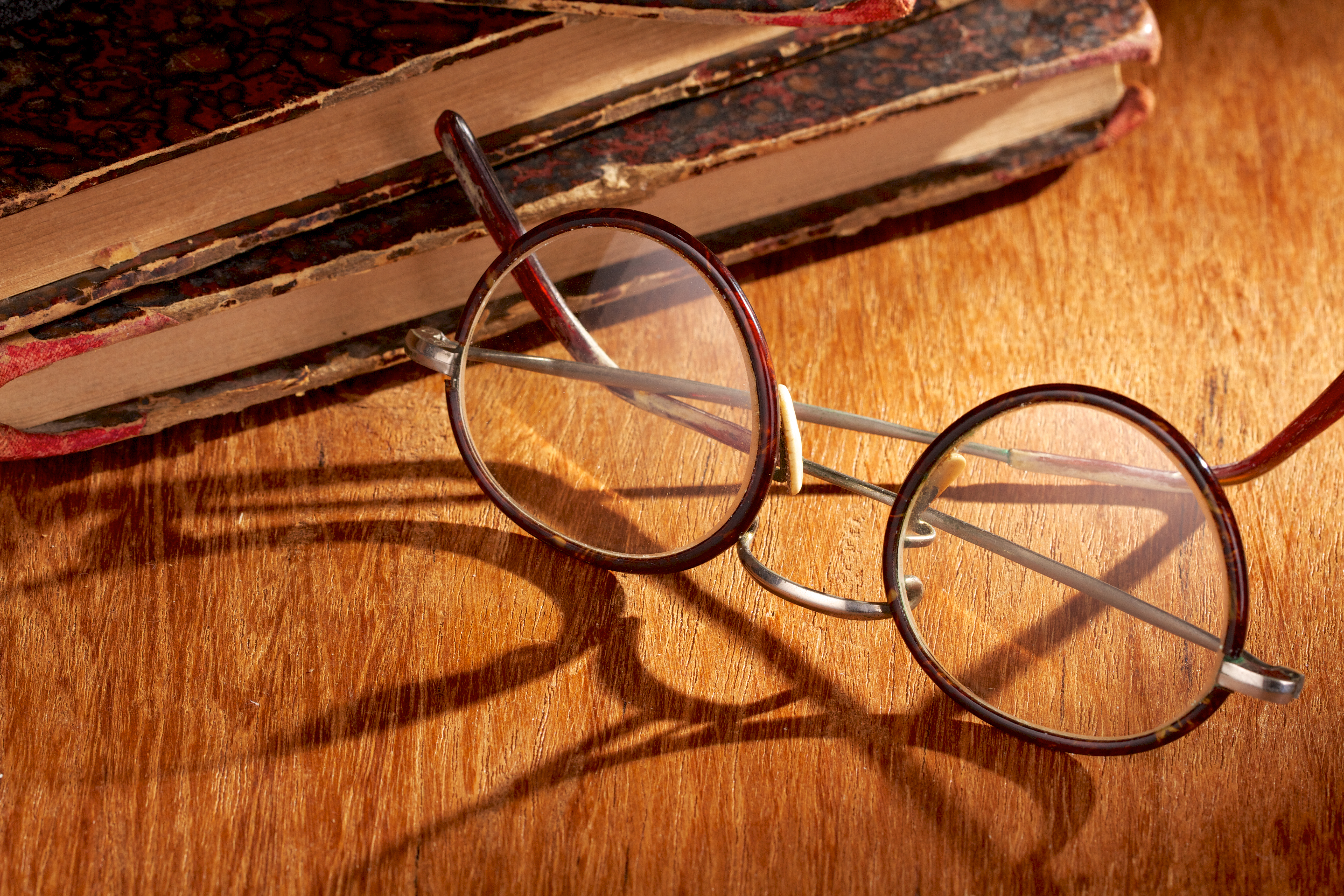 Long shadow from vintage eyewear over a wooden table