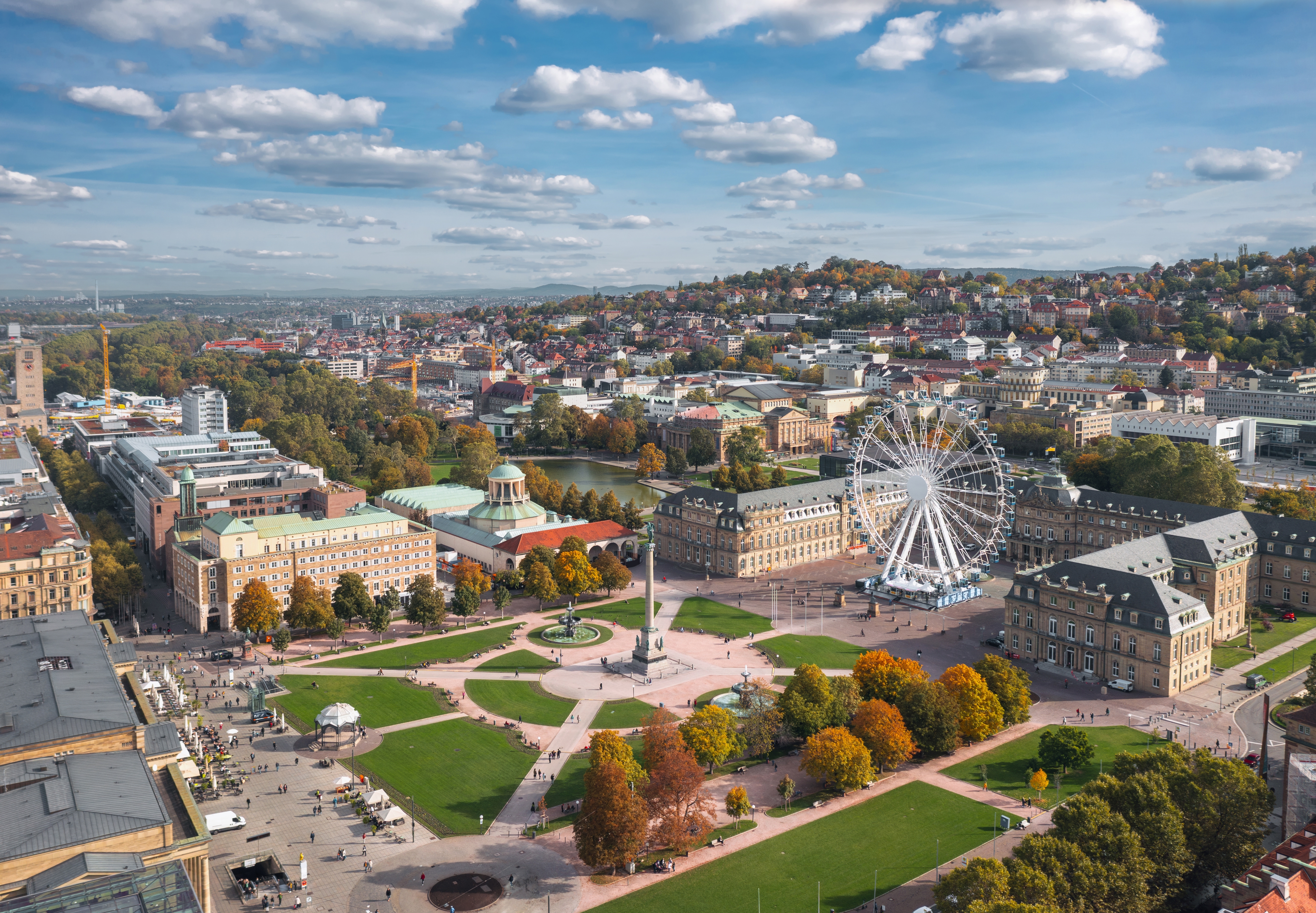 Beautiful autumn skyline cityscape of Stuttgart Mitte, Baden-württemberg, Germany at sunset. Ferris wheel and Jubiläumssäule at Schlossplatz in front of Neues schloss