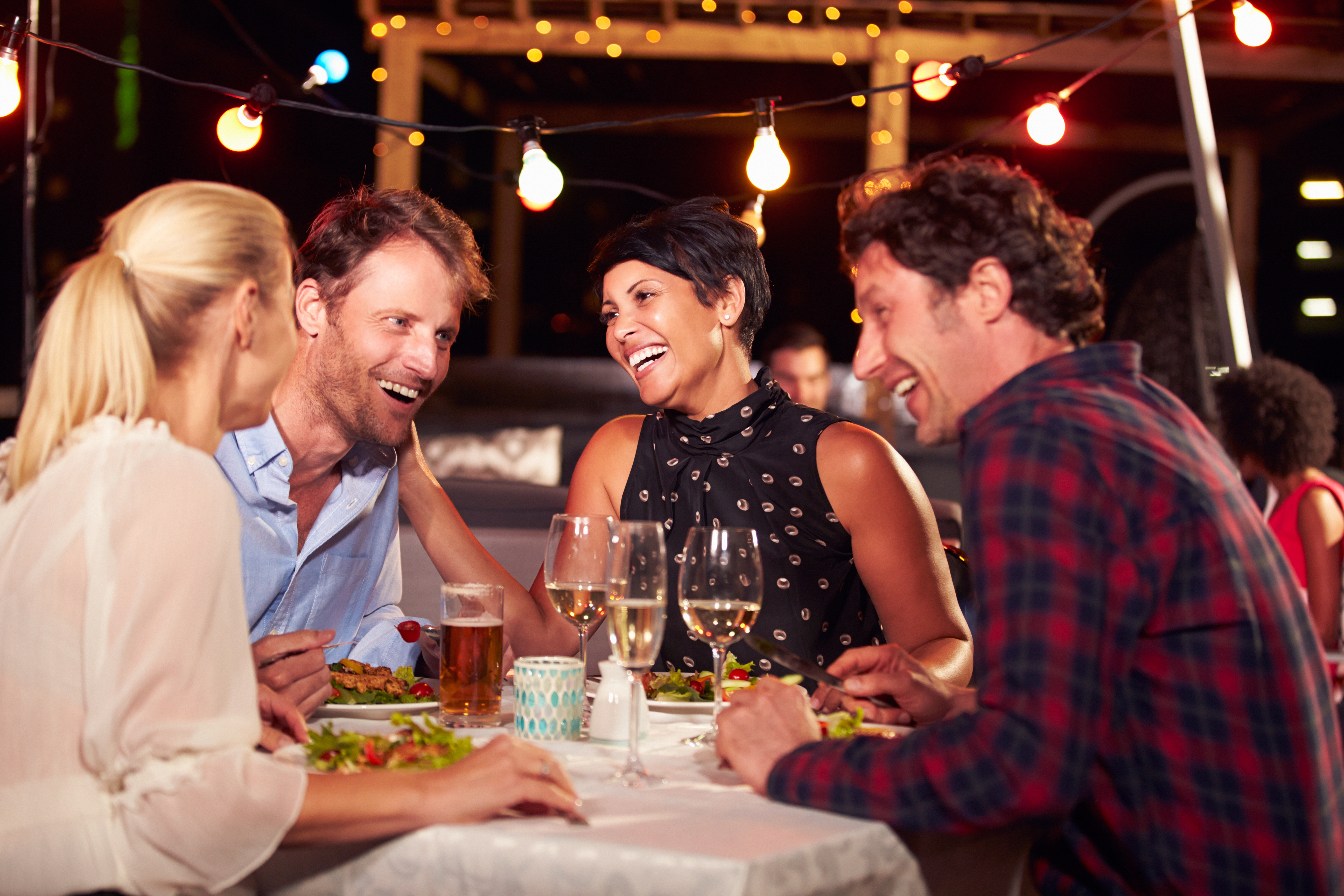 Group of friends eating dinner at rooftop restaurant