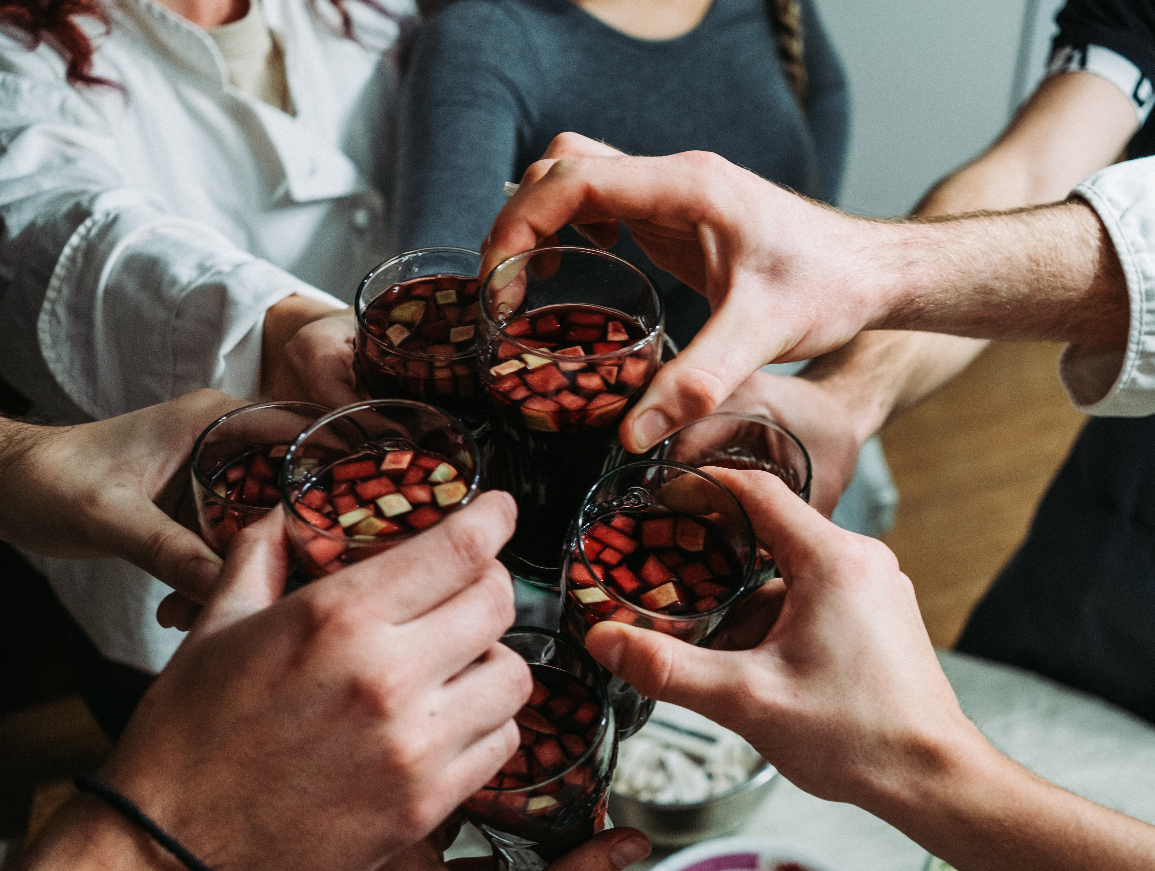 people making a toast with homemade sangria