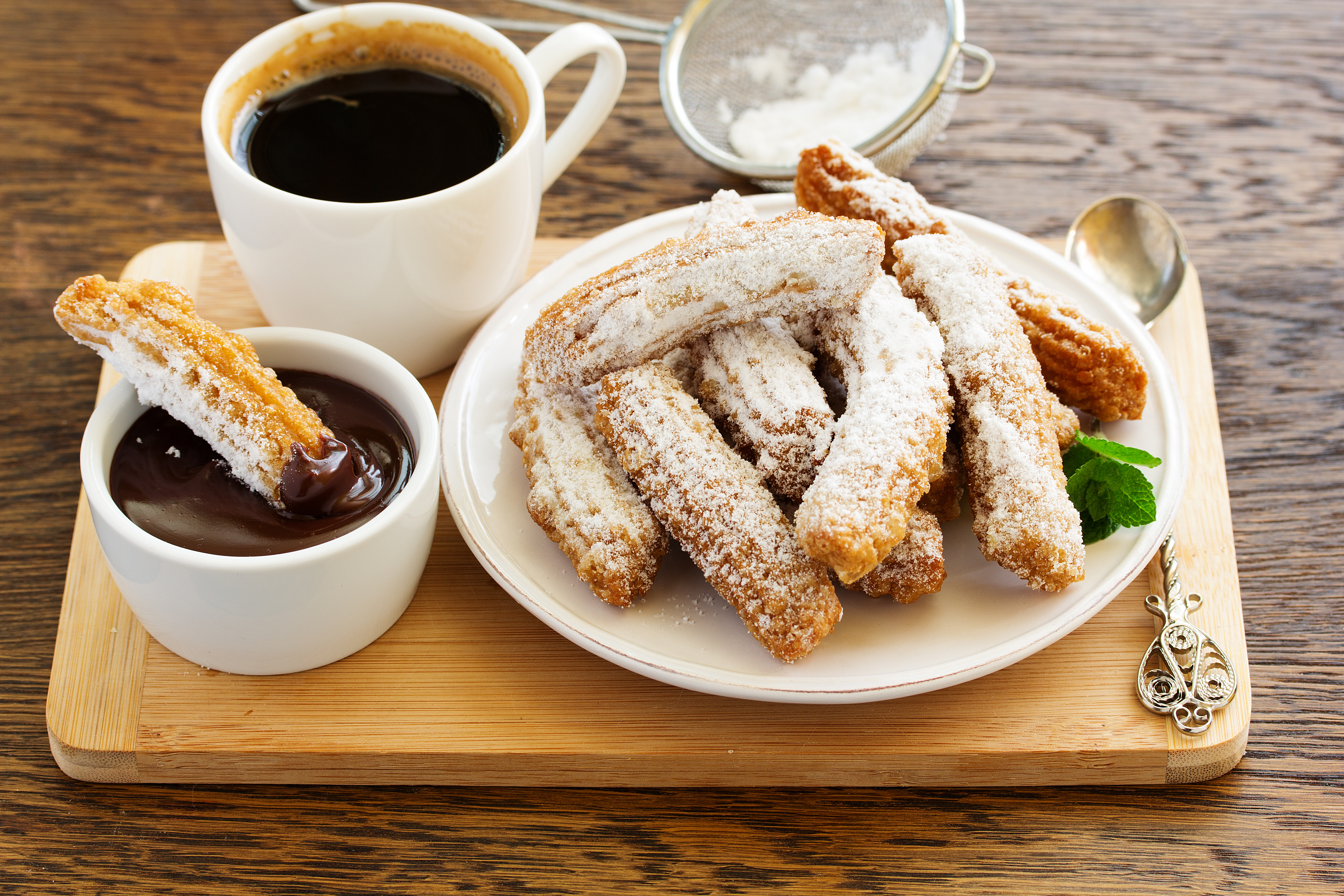 Churros with powdered sugar, chocolate and coffee