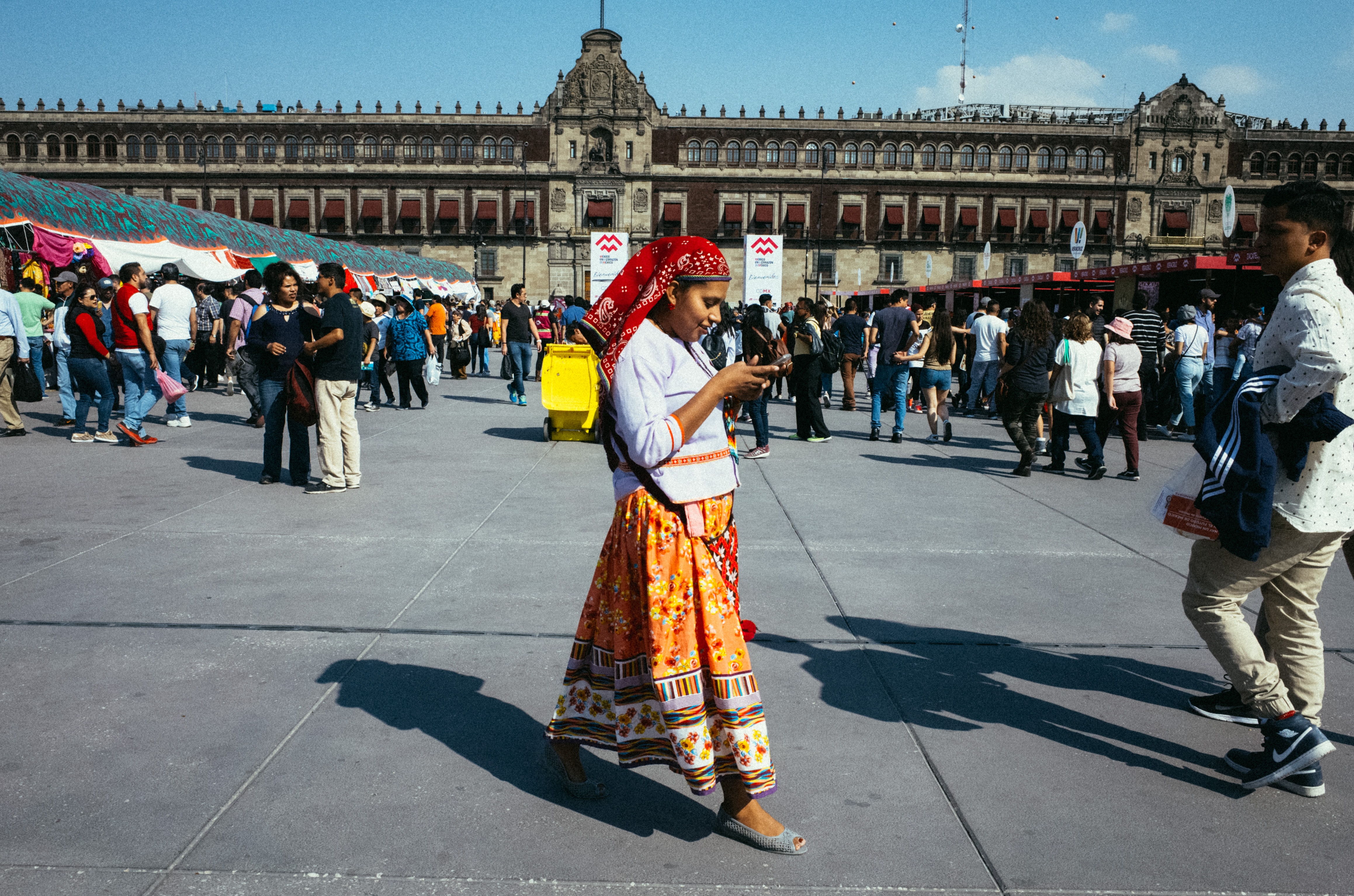 mowan in traditional clothes looking at her phone, Centro Historico, CDMX