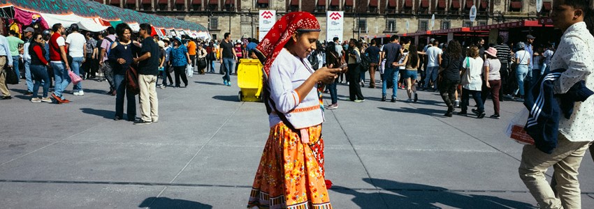 mowan in traditional clothes looking at her phone, Centro Historico, CDMX