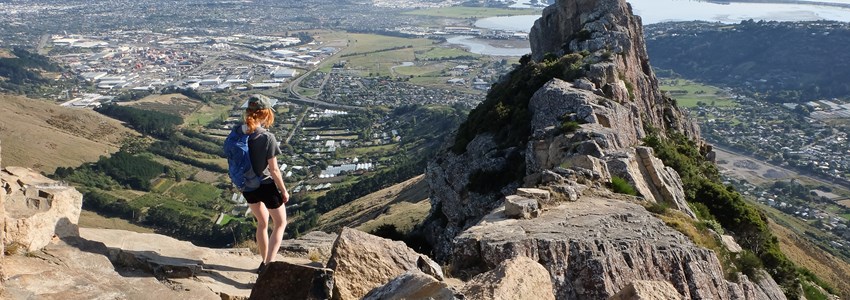 Woman Hiker Ascending Castle Rock. Port Hills, Christchurch, New Zealand.
